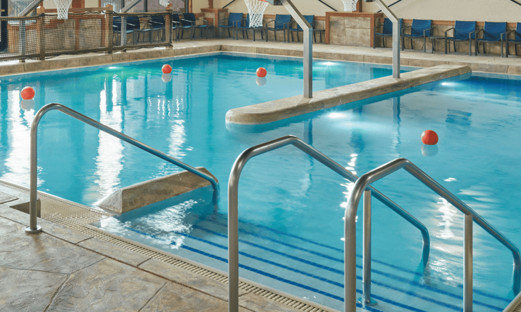  A spacious indoor pool featuring a large slide and multiple water slides for recreational enjoyment.