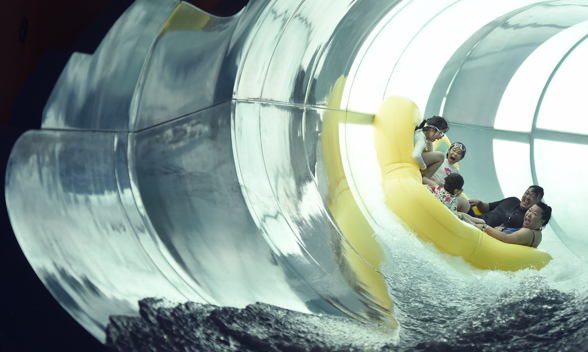 Family of five rides down enclosed water slide