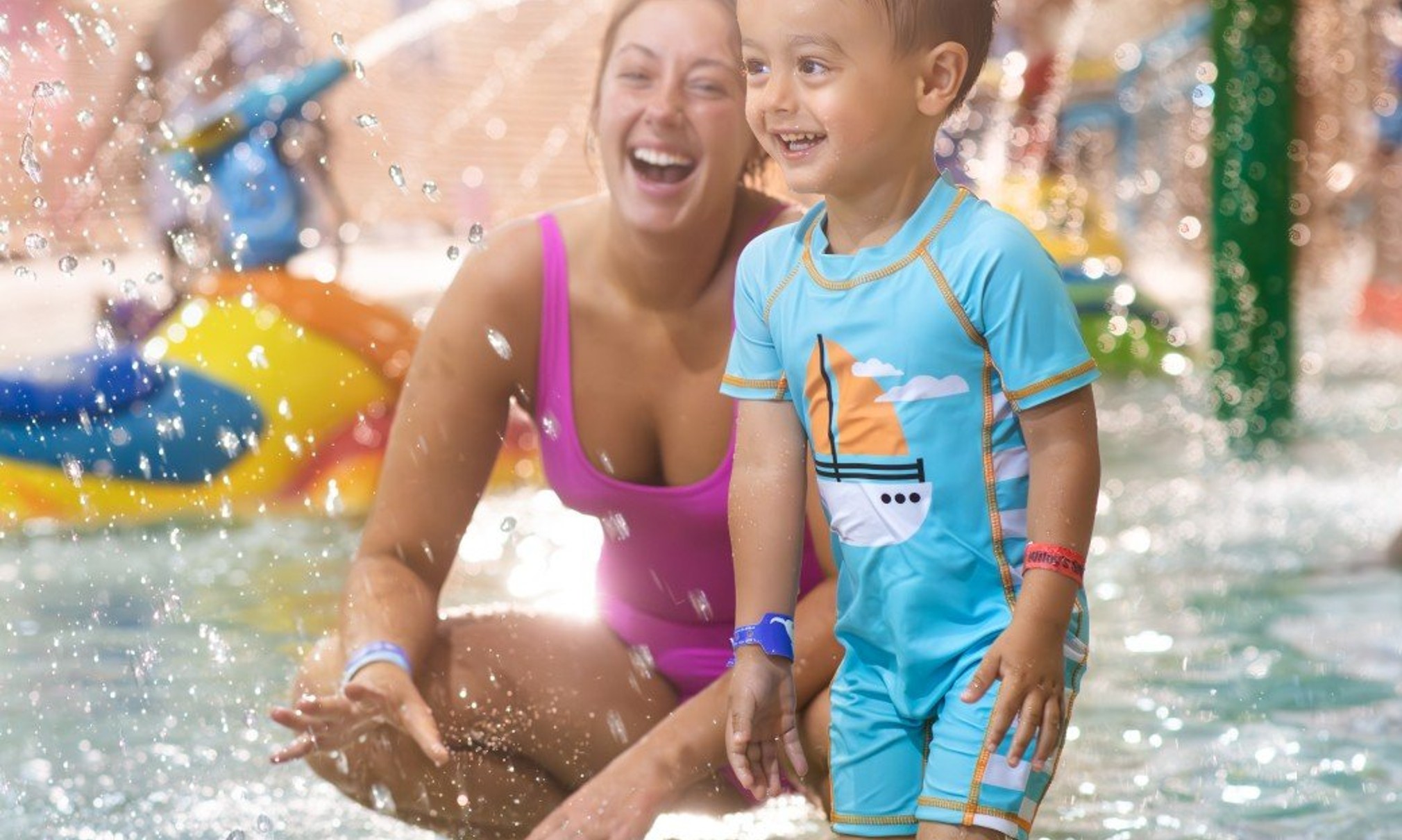 mother and child playing in a kiddie pool