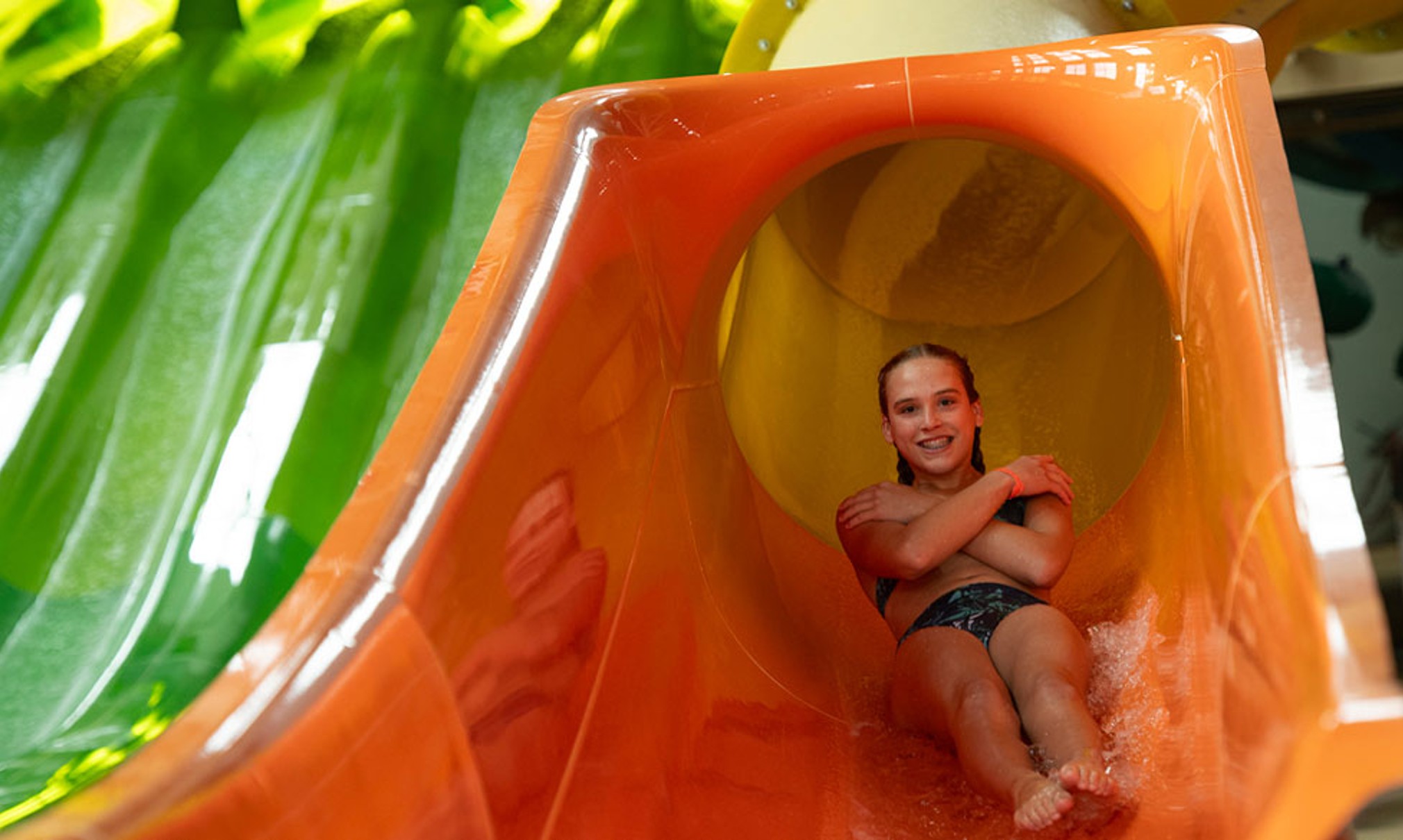 a girl coming down a yellow slide