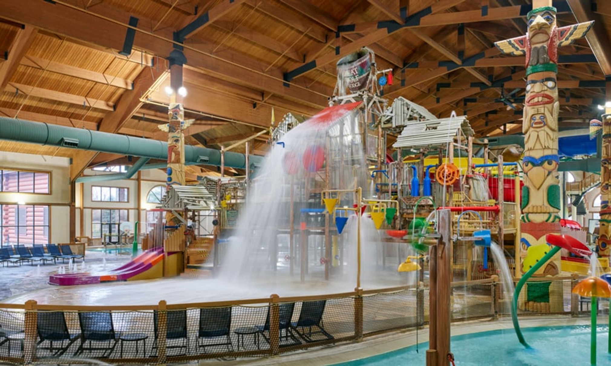 A wide shot of the  water treehouse as water splashes down from a bucket above the jungle gym