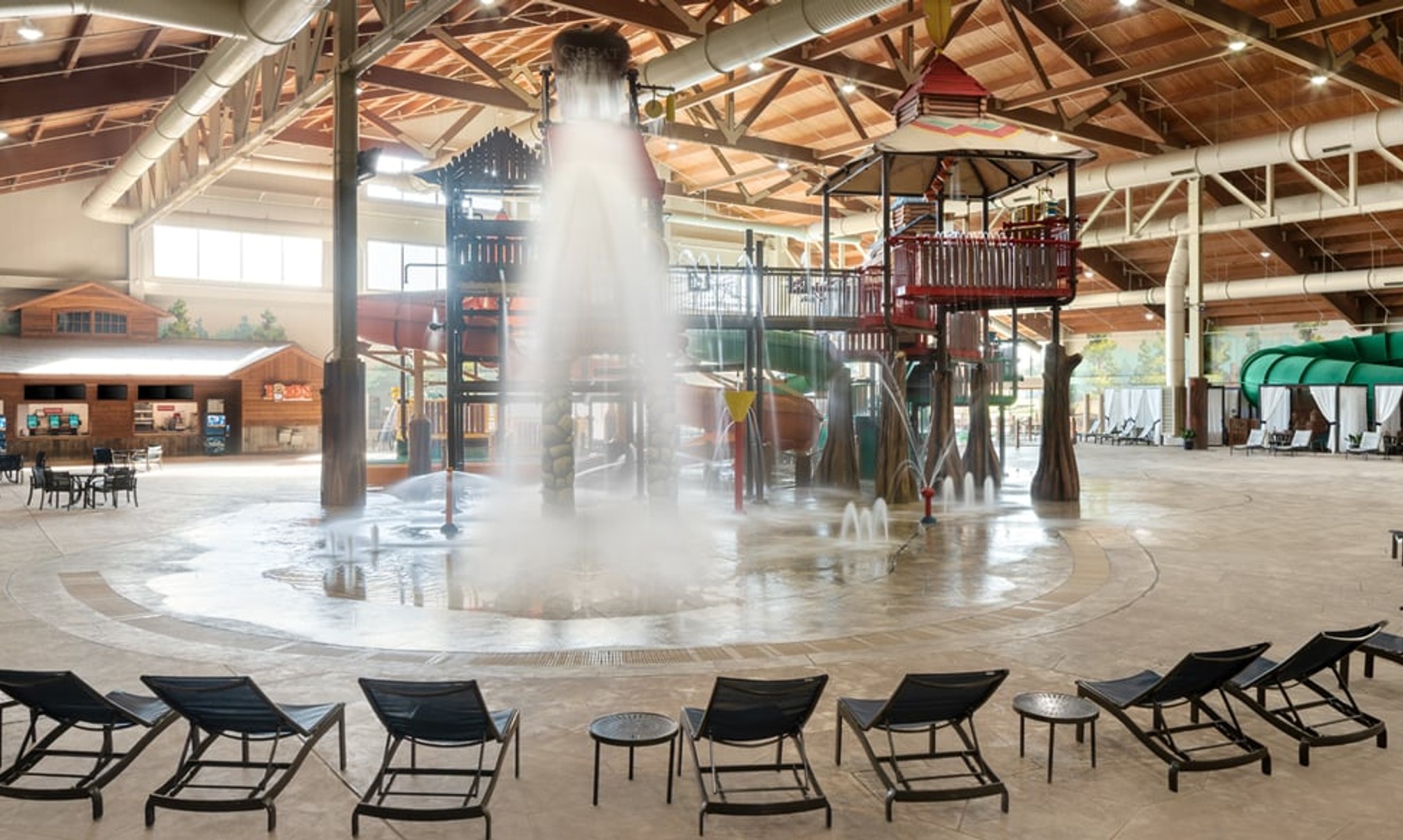 A wide shot of the  water treehouse as water splashes down from a bucket above the jungle gym