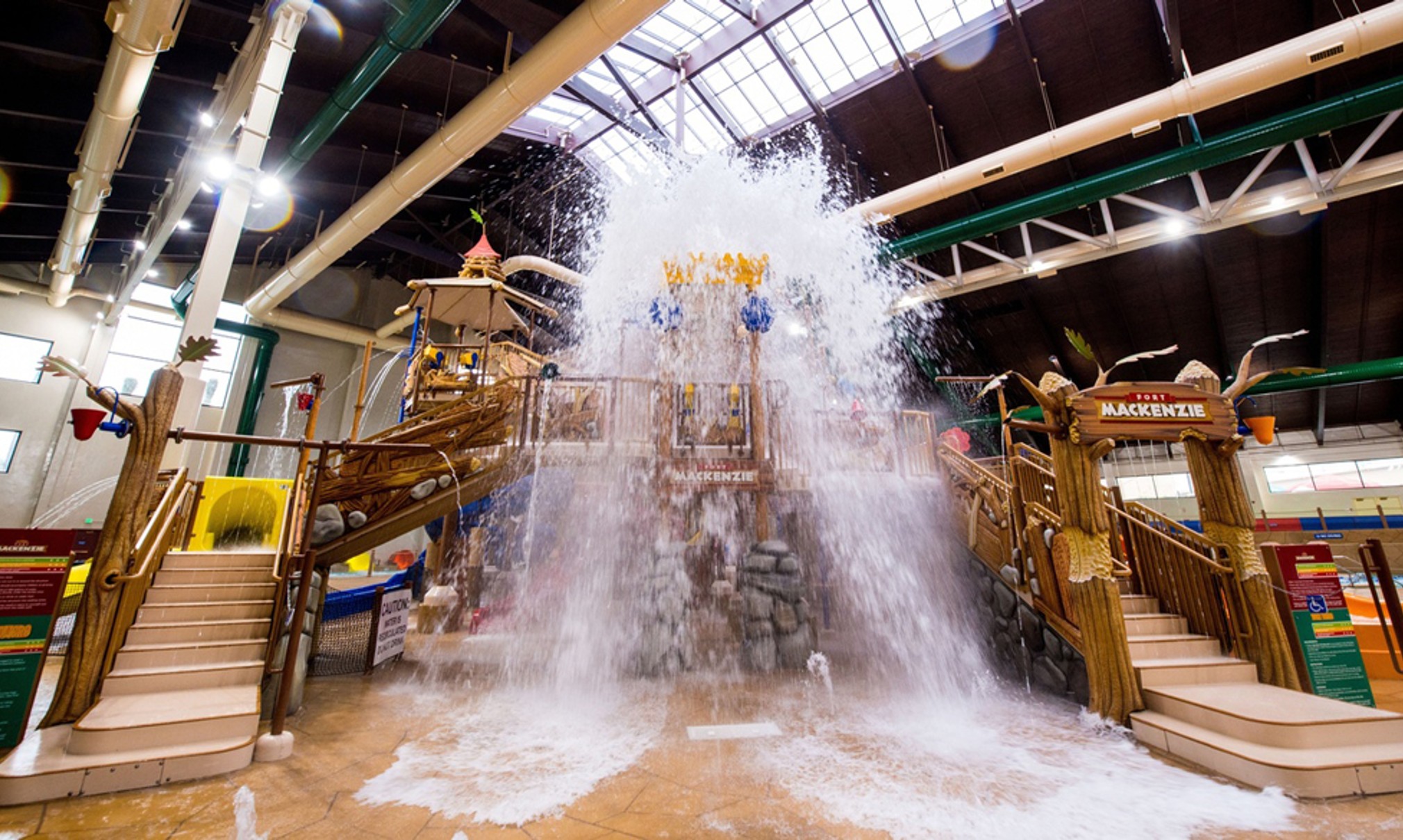 A wide shot of the  water treehouse as water splashes down from a bucket above the jungle gym
