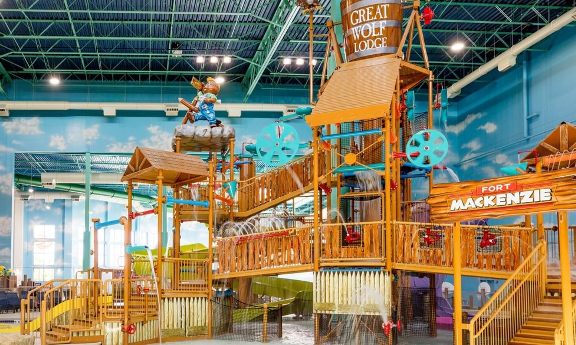 A wide shot of the  water treehouse as water splashes down from a bucket above the jungle gym
