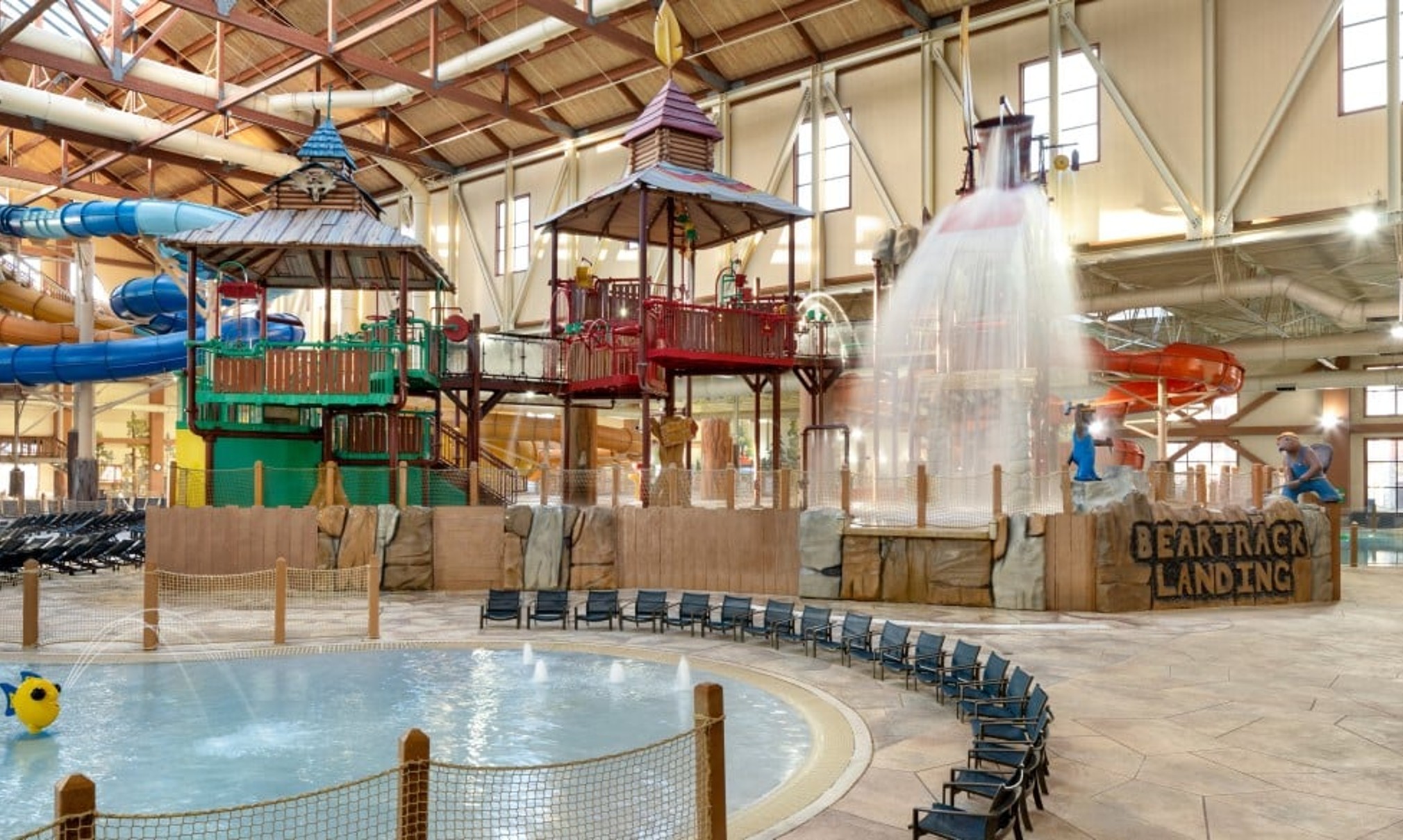 A wide shot of the  water treehouse as water splashes down from a bucket above the jungle gym