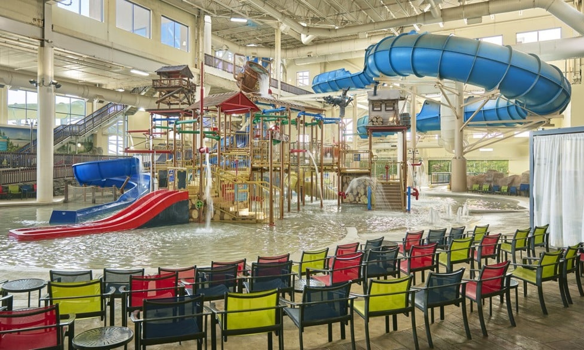 A wide shot of the  water treehouse as water splashes down from a bucket above the jungle gym