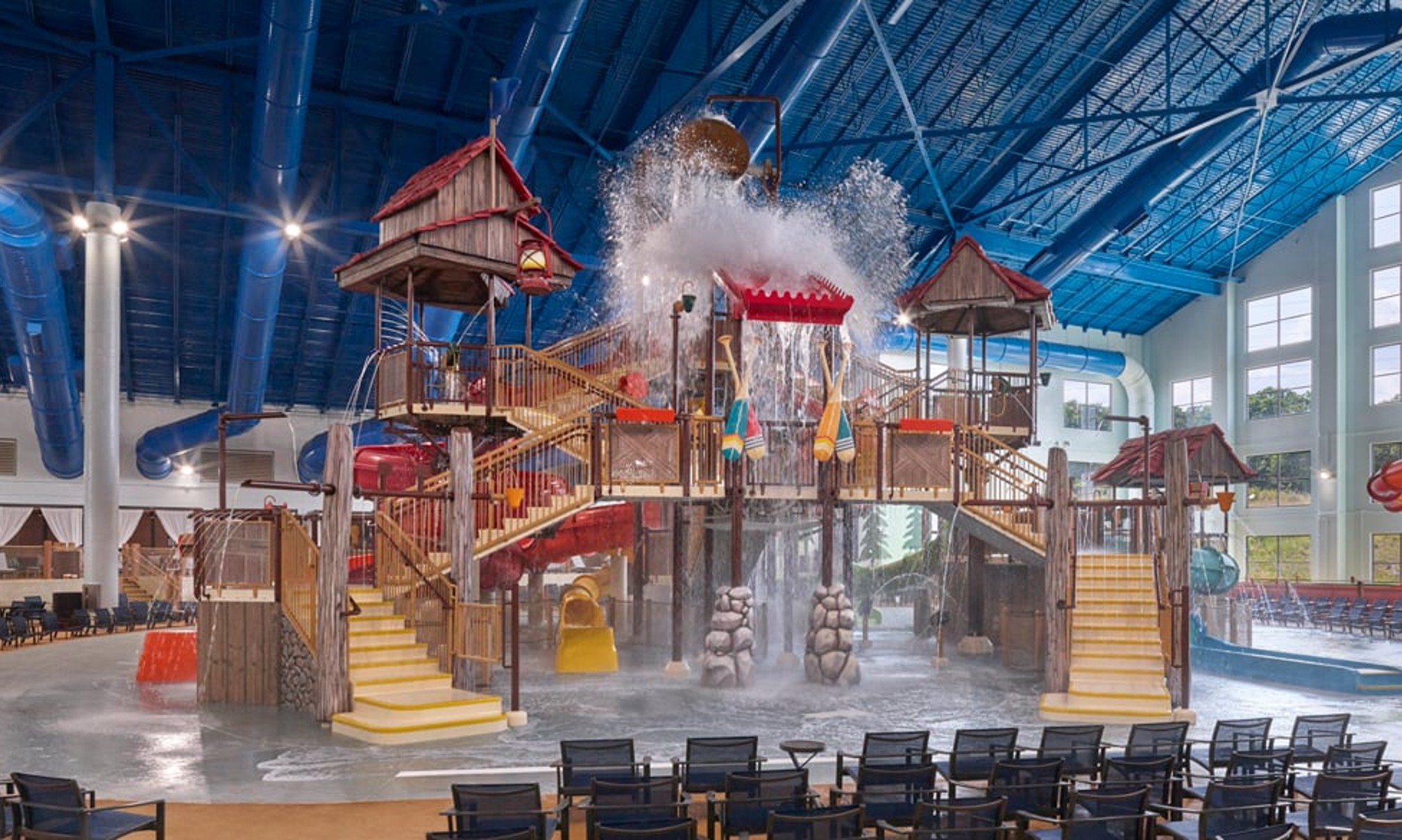 A wide shot of the  water treehouse as water splashes down from a bucket above the jungle gym
