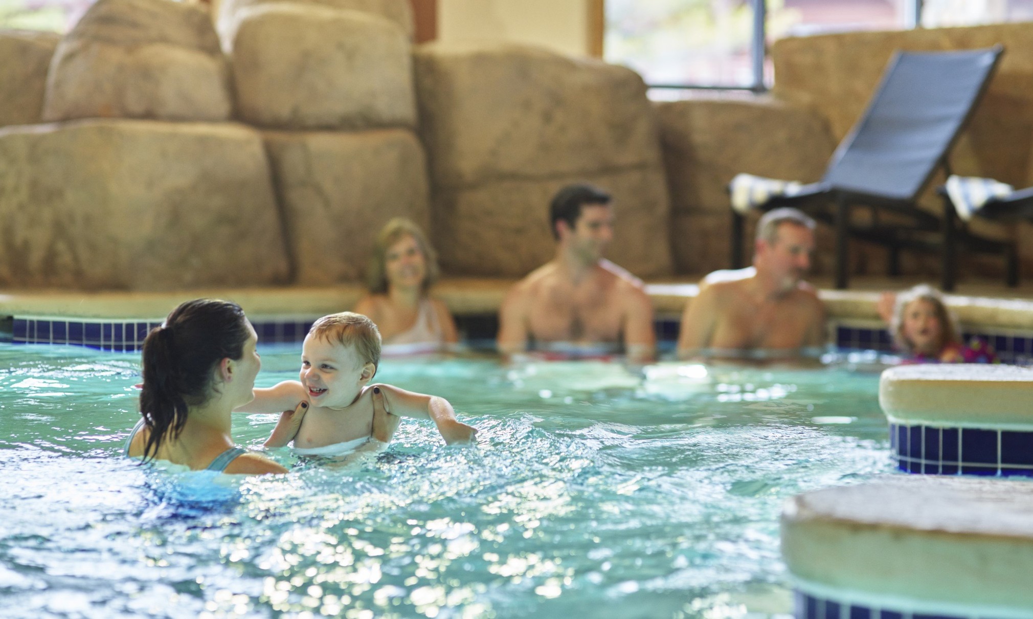 A family relaxes in an indoor hot tub