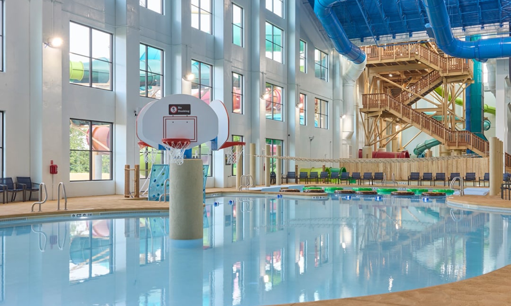 family playing basketball in indoor pool 