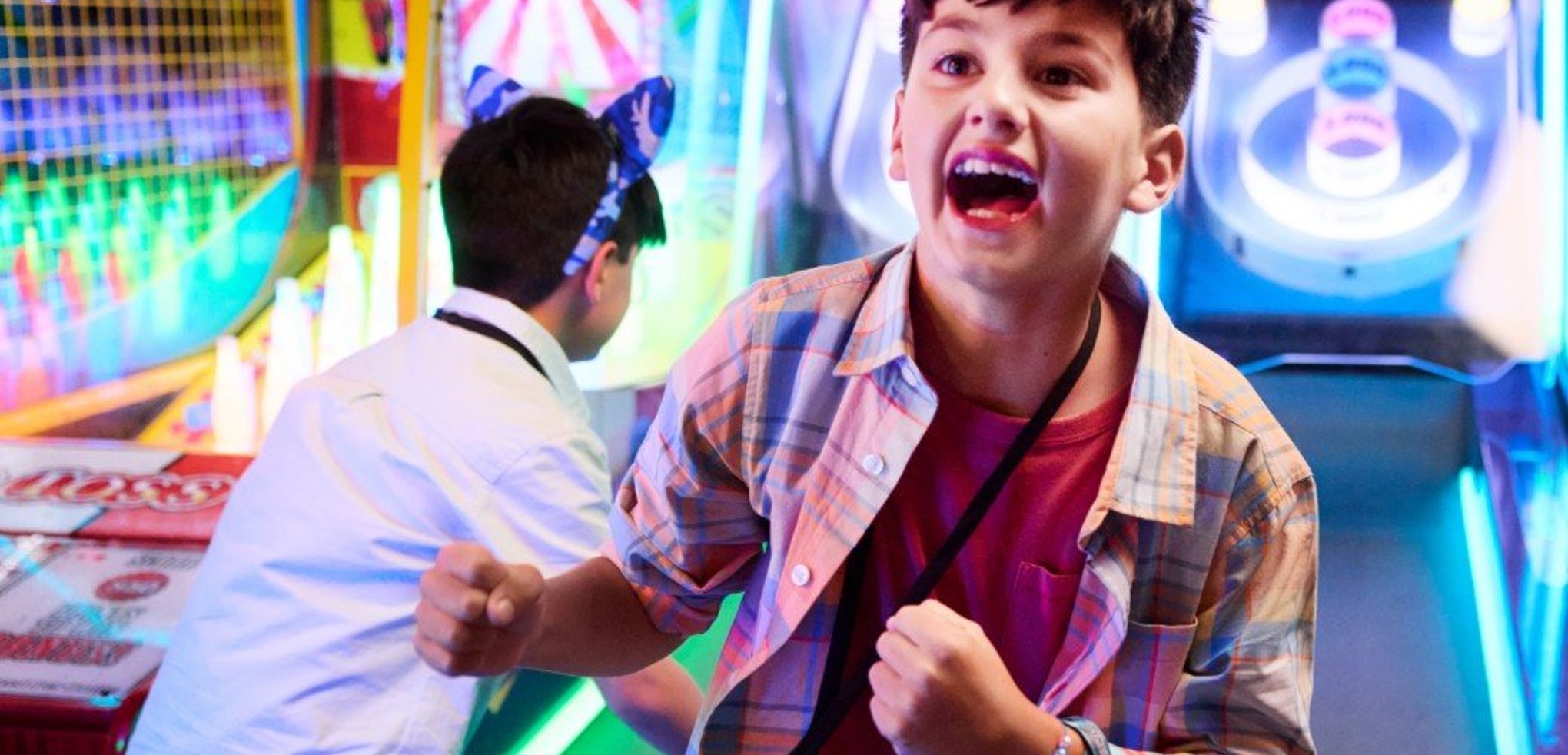 Boy celebrating while playing arcade basketball game