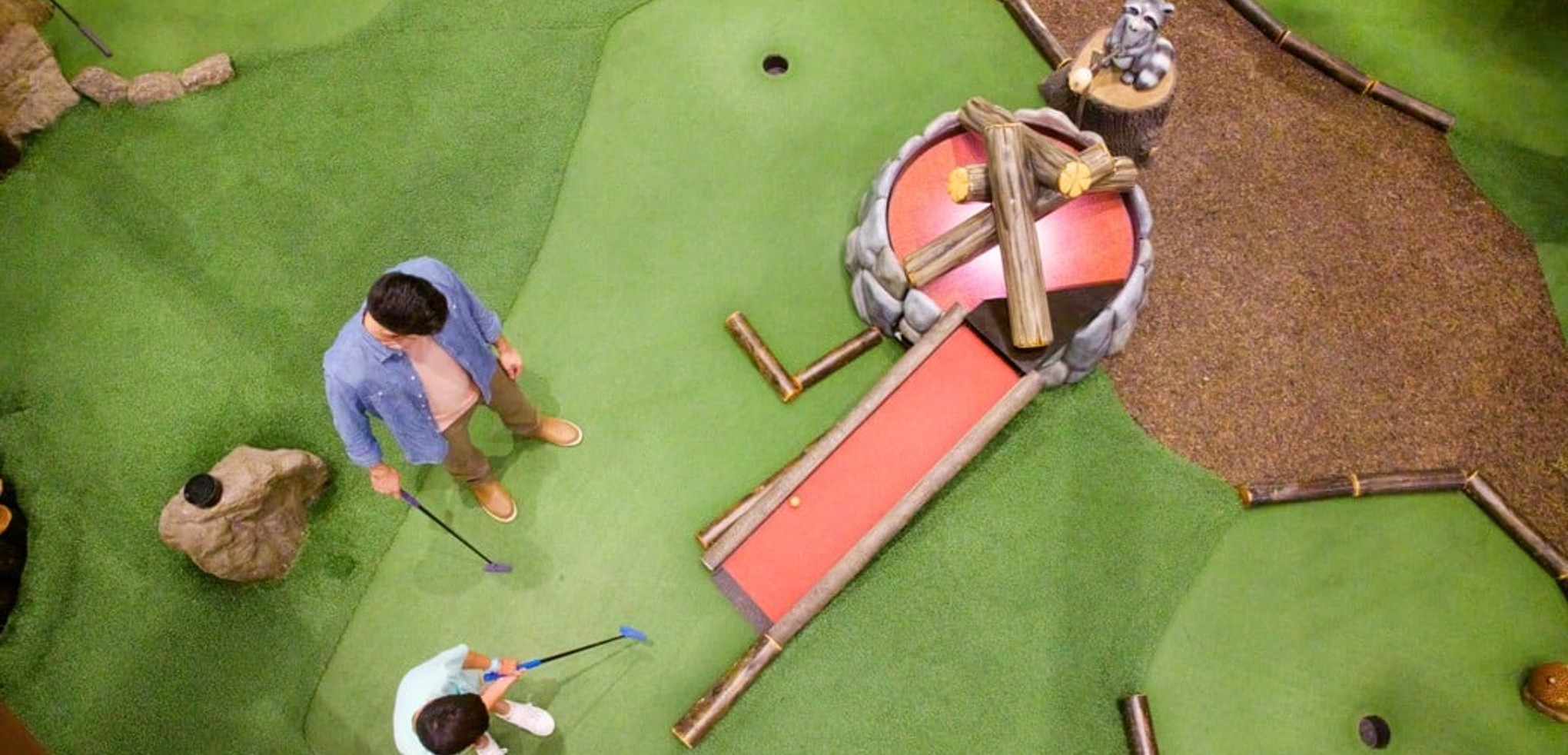 A father and son plays a round of mini golf at Great Wolf Resorts