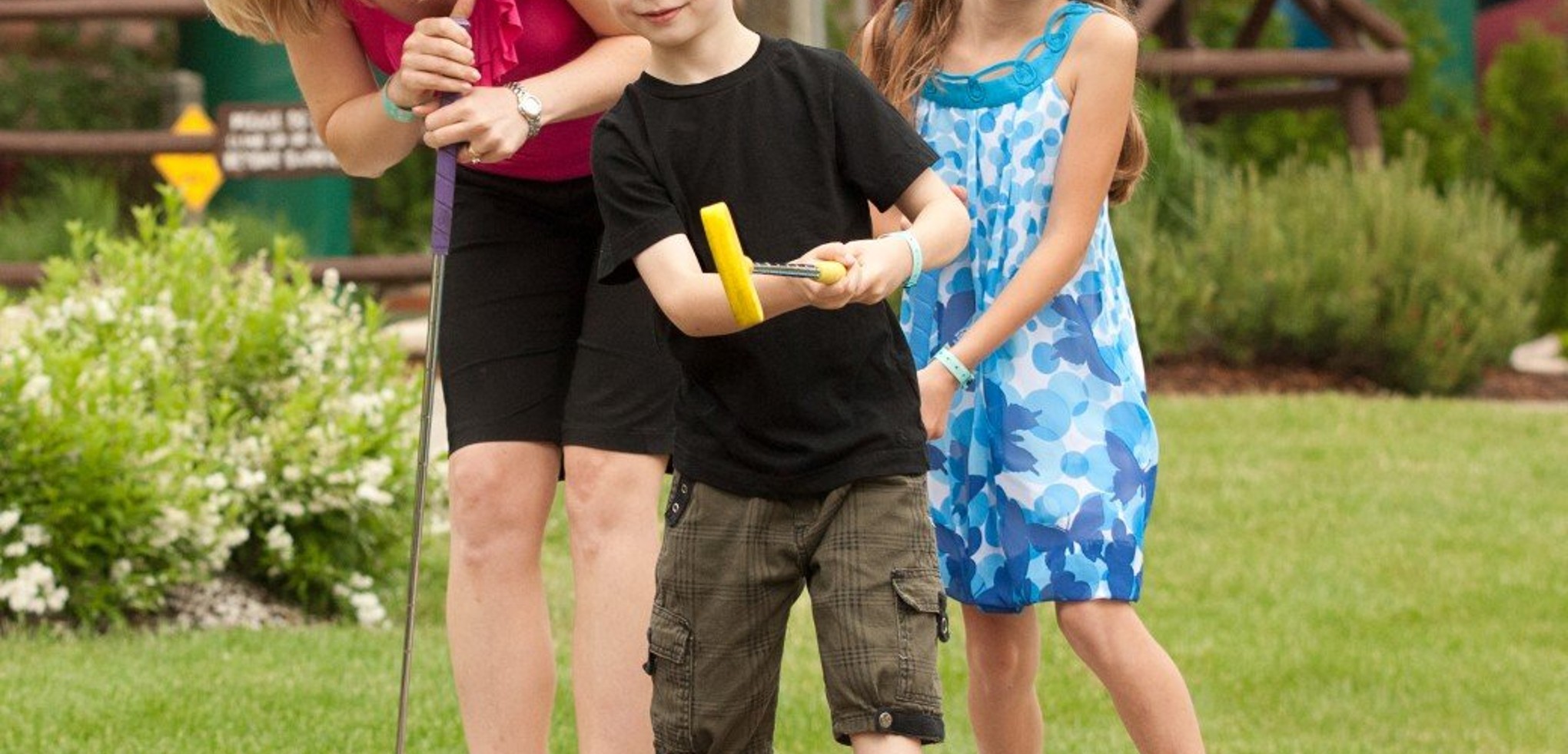 A family plays a round of mini golf 
