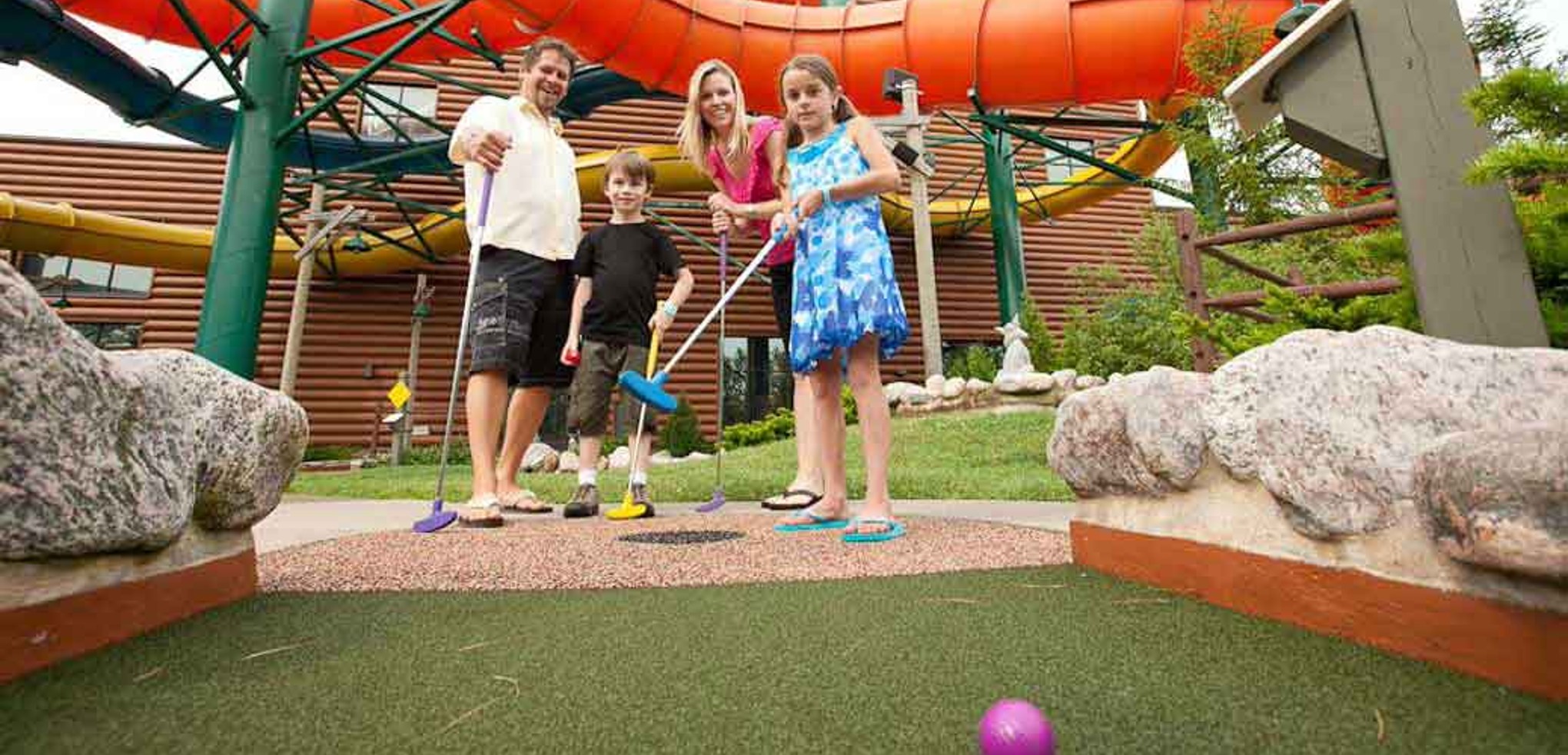 A family plays a round of mini golf 
