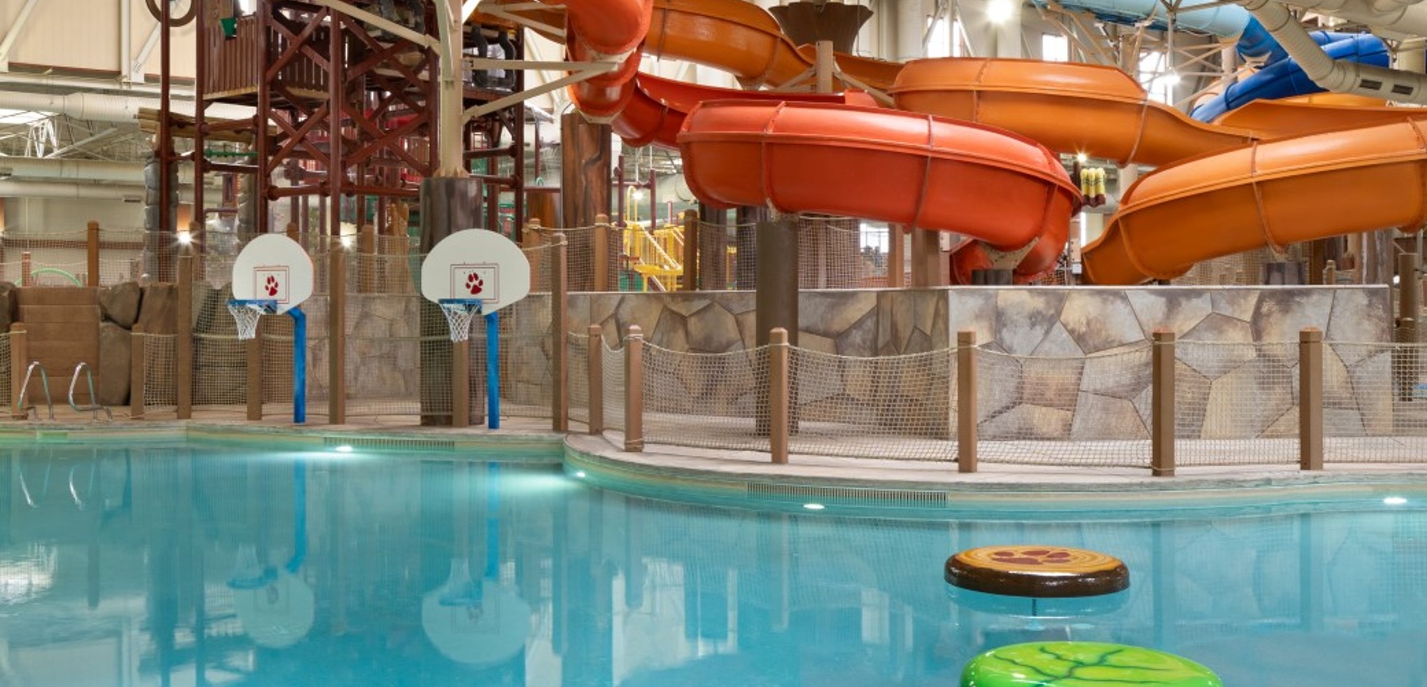 family playing basketball in indoor pool 
