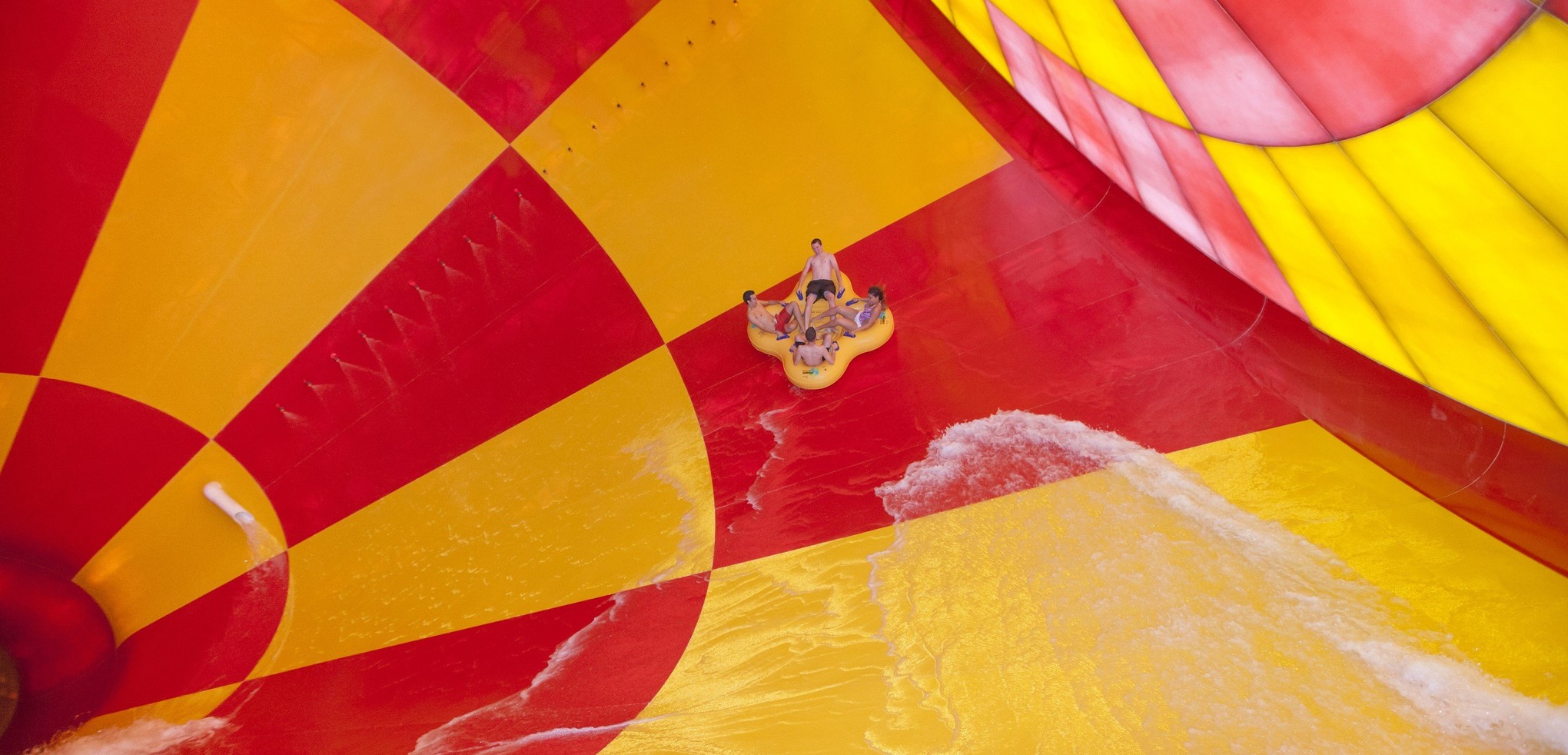 4 people on a 4-person tube riding dwn the howlin' tornado water park ride