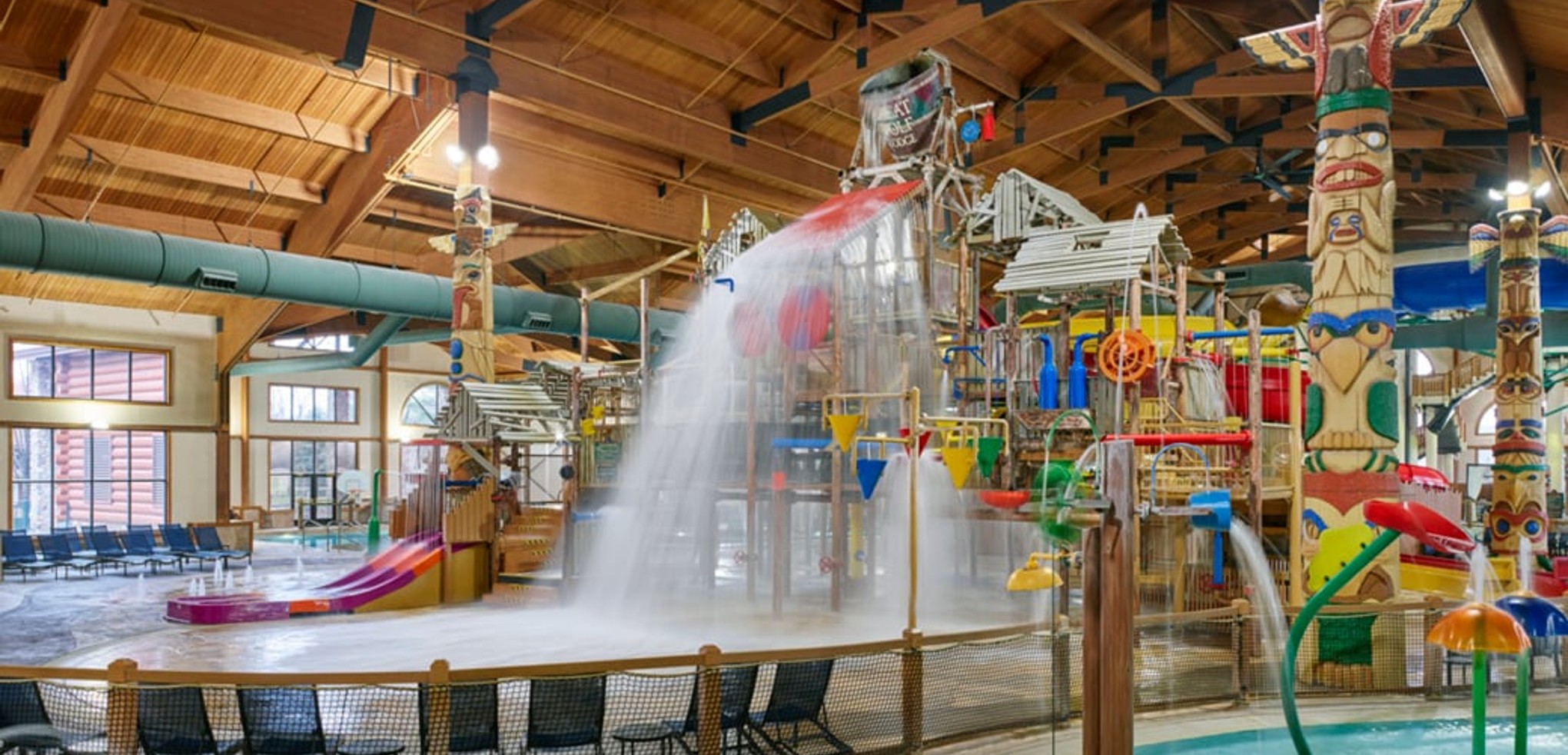 A wide shot of the  water treehouse as water splashes down from a bucket above the jungle gym