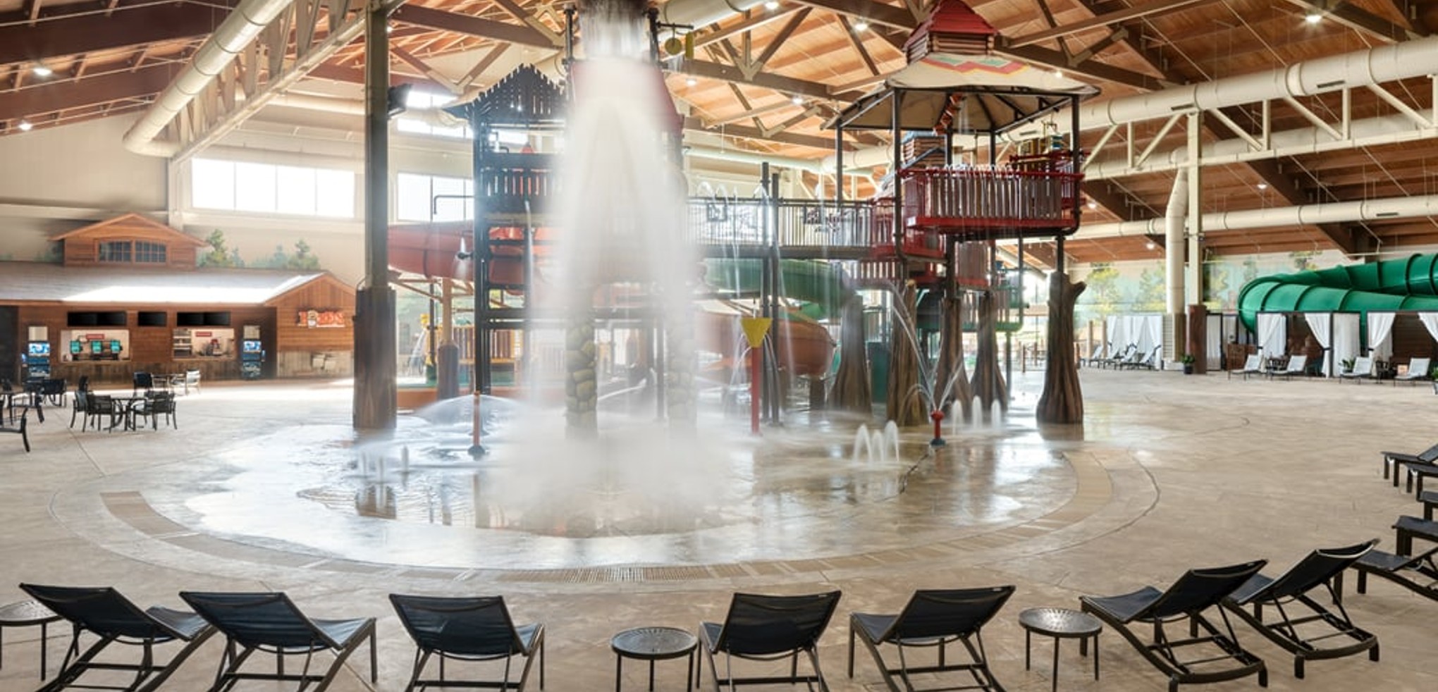 A wide shot of the  water treehouse as water splashes down from a bucket above the jungle gym