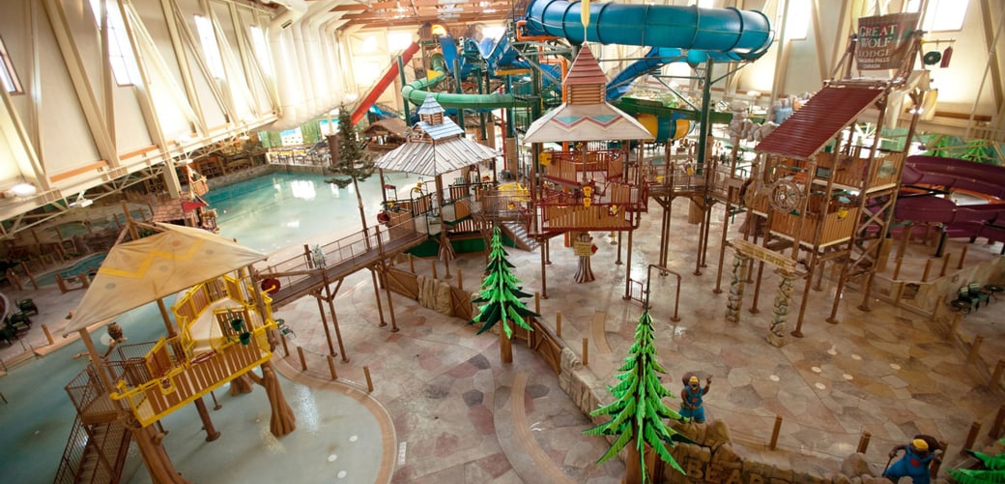 A wide shot of the  water treehouse as water splashes down from a bucket above the jungle gym