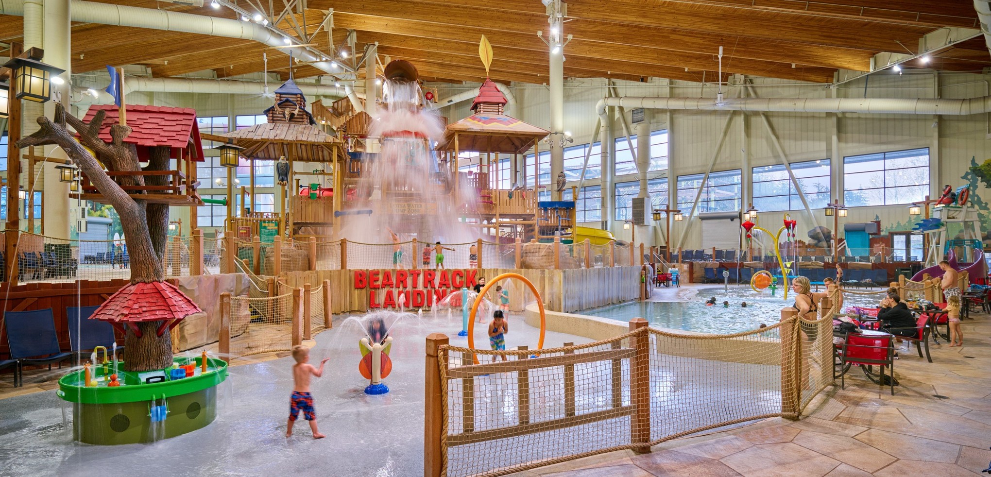 A wide shot of the  water treehouse as water splashes down from a bucket above the jungle gym