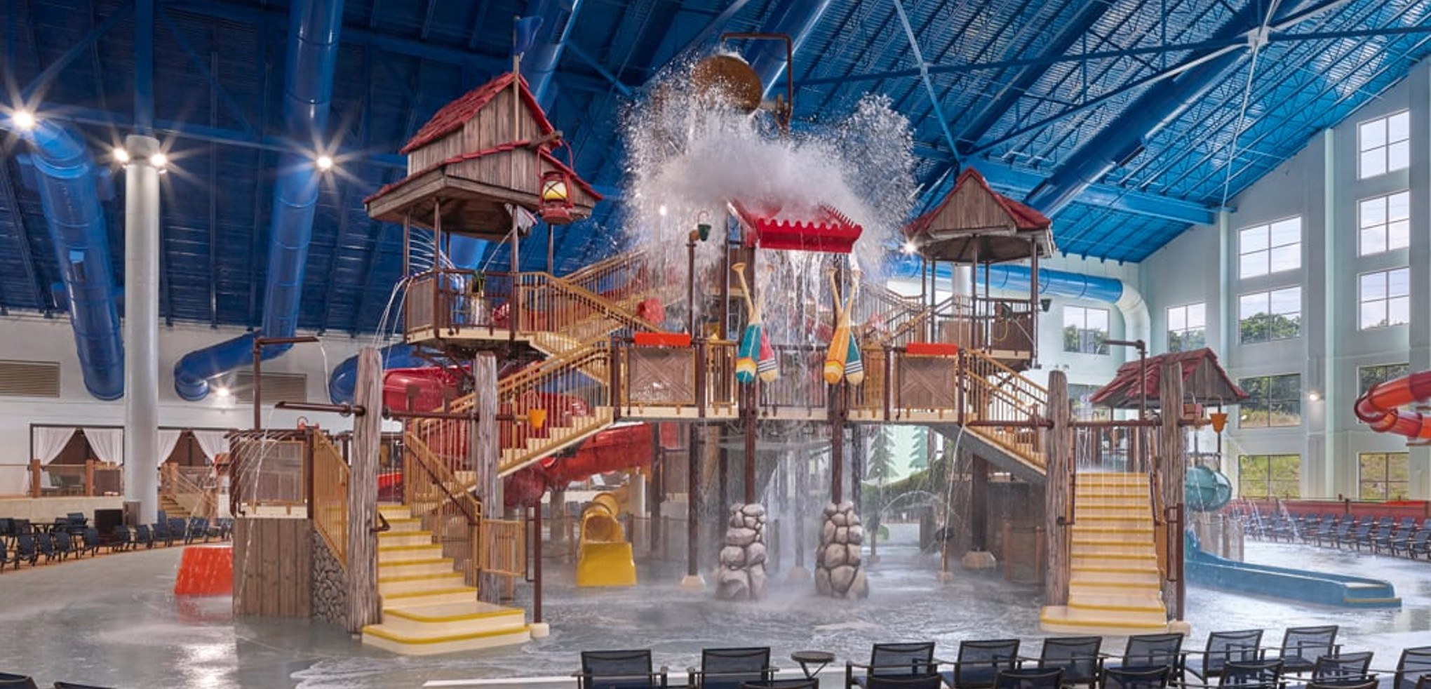 A wide shot of the  water treehouse as water splashes down from a bucket above the jungle gym