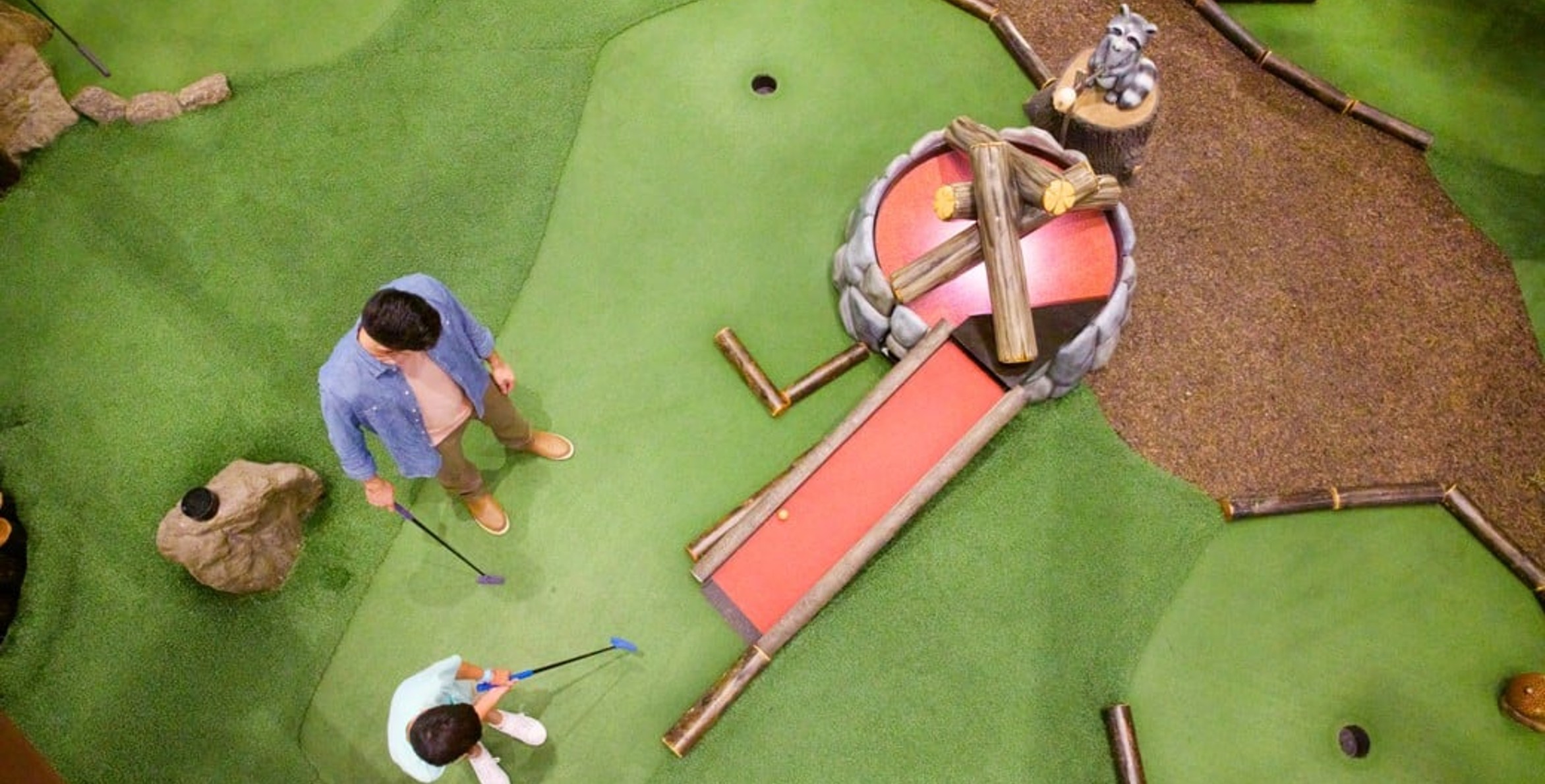A father and son plays a round of mini golf at Great Wolf Lodge indoor water park and resort.