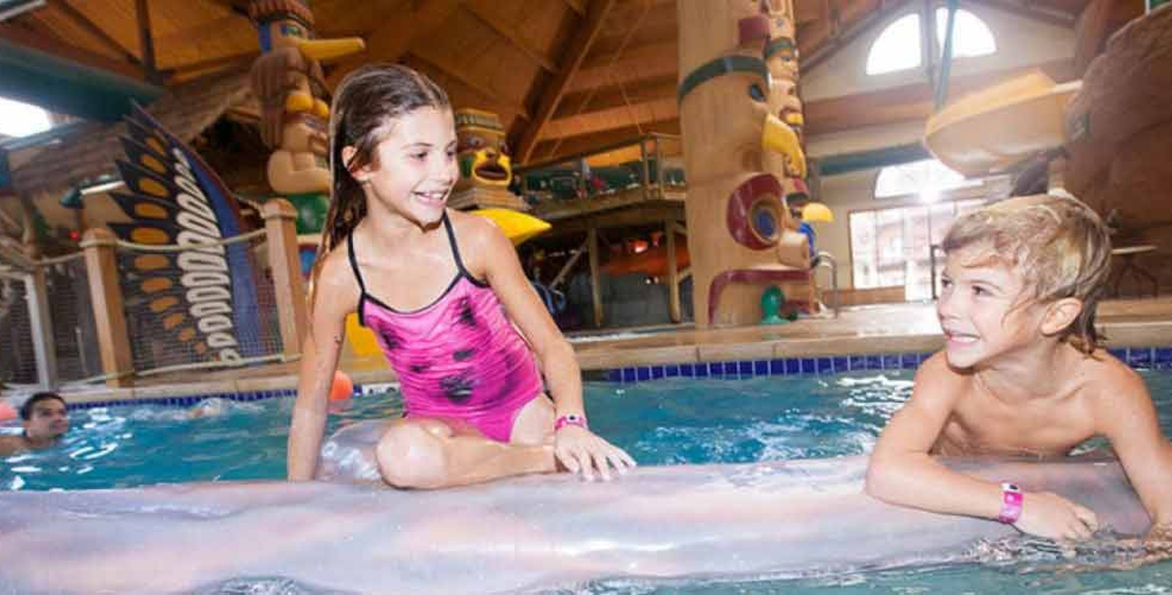 Child balances on log at Great Wolf Lodge indoor water park and resort.