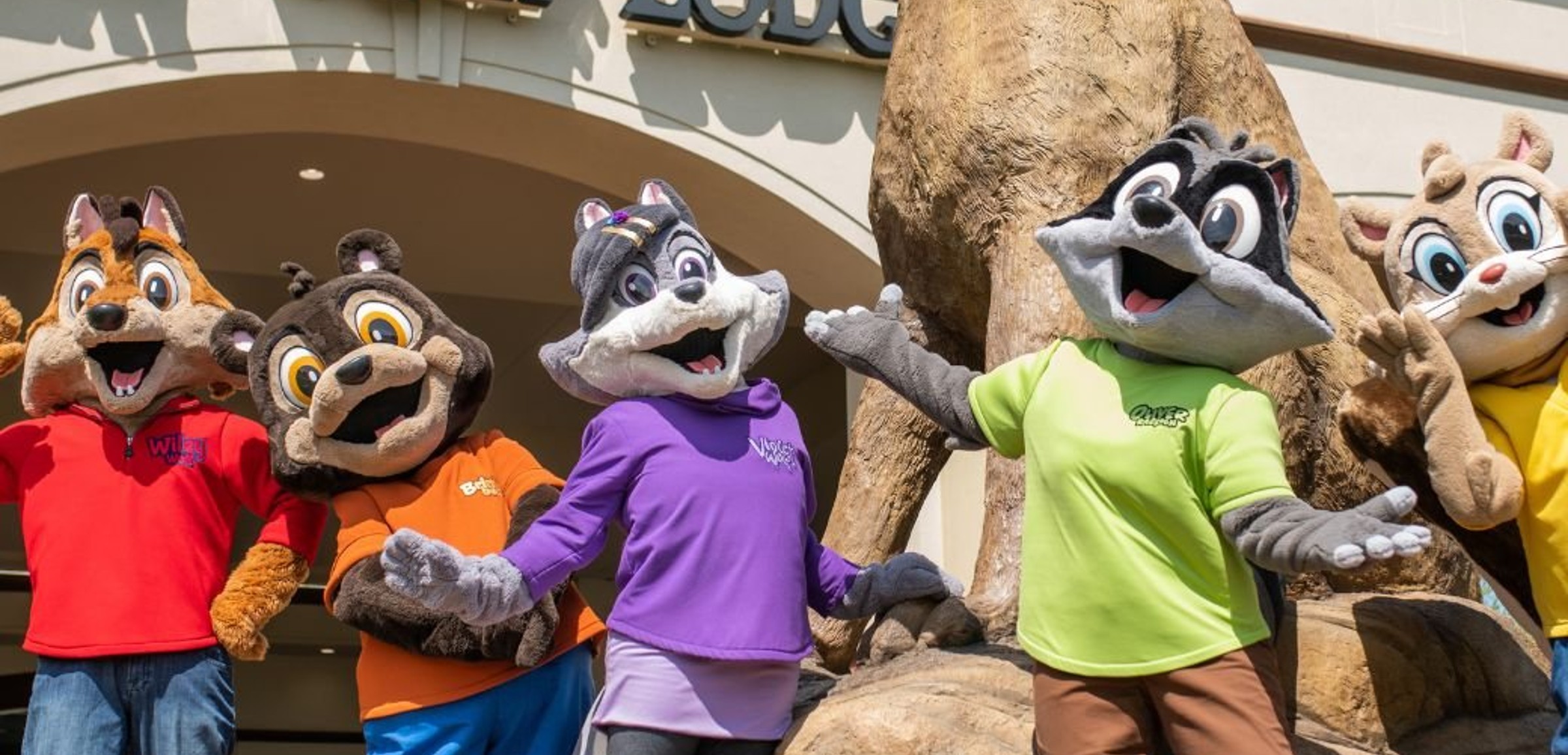 Great Wolf Lodge mascots posing in front of entrance statue