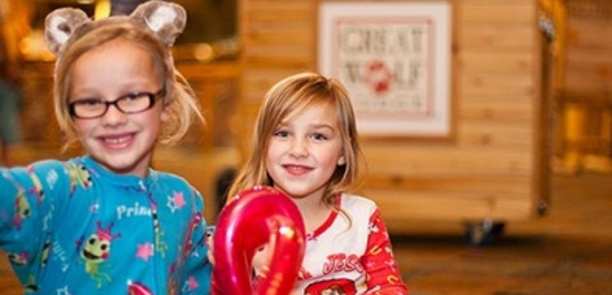 Two girls smile at the camera while at Great Wolf Lodge indoor water park and resort.