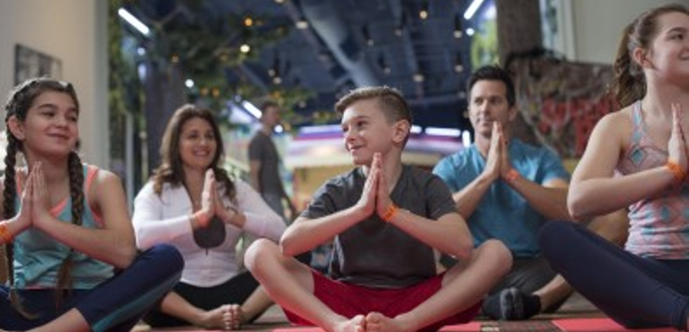 Family doing yoga at Wake Up with Wiley and Friends at Great Wolf Lodge indoor water park and resort.