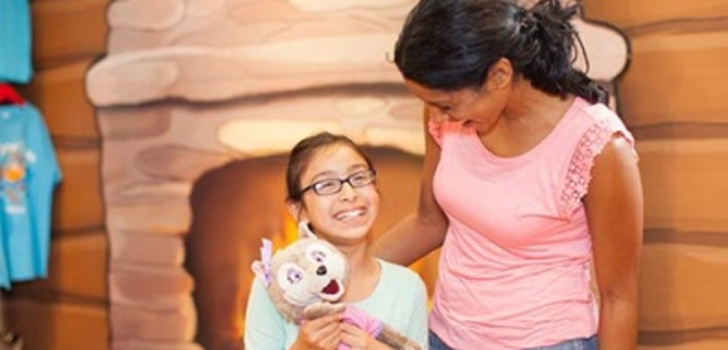 A girl smiles up at her mom at Great Wolf Lodge indoor water park and resort.