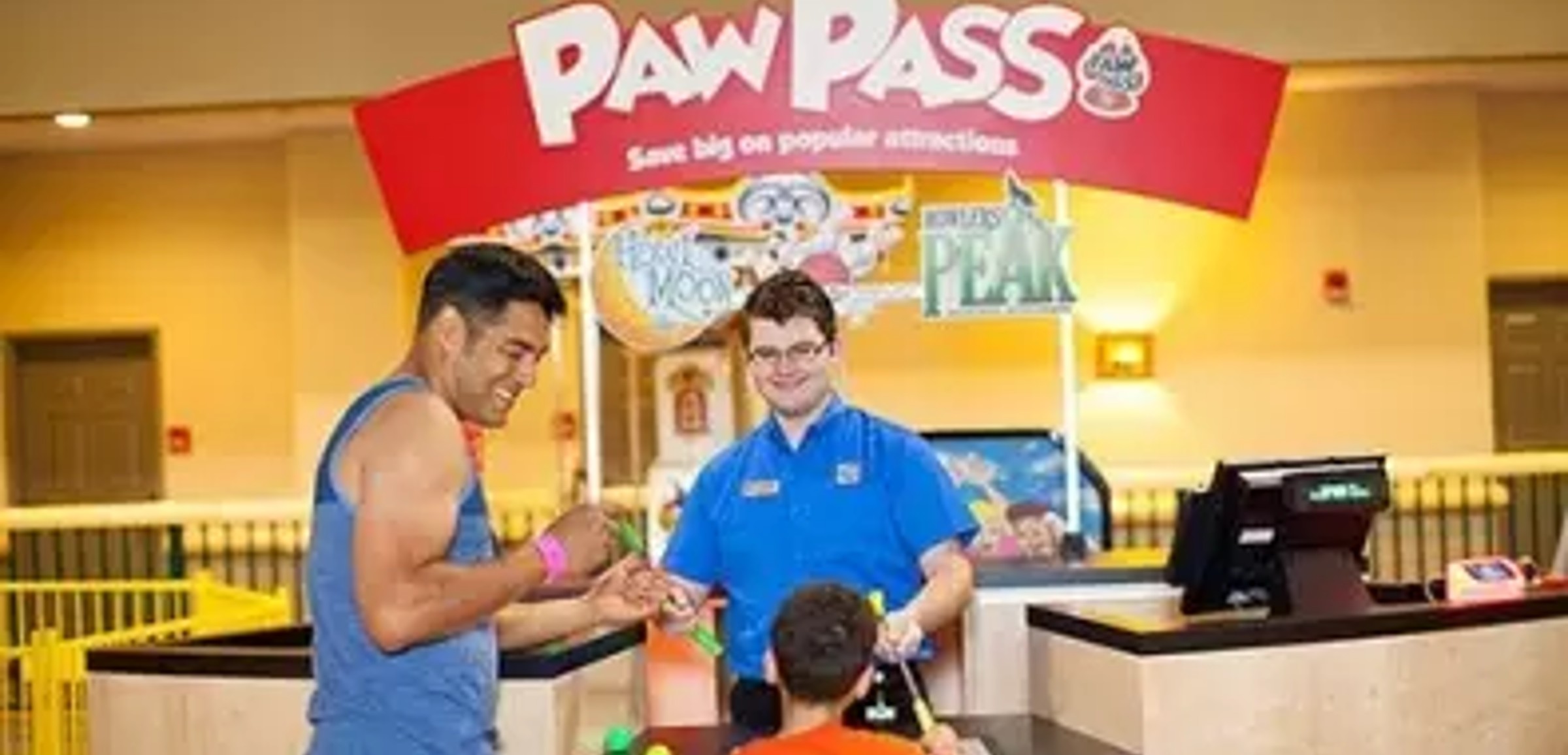 A father and son at the Howl at the Moon Mini Golf counter at Great Wolf Lodge indoor water park and resort.