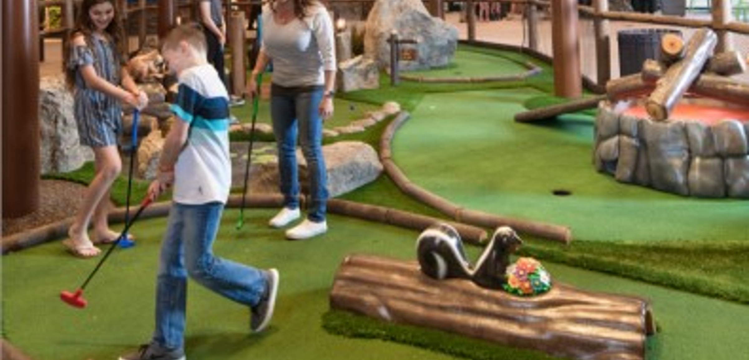 A family plays a round of mini golf at Great Wolf Lodge indoor water park and resort.