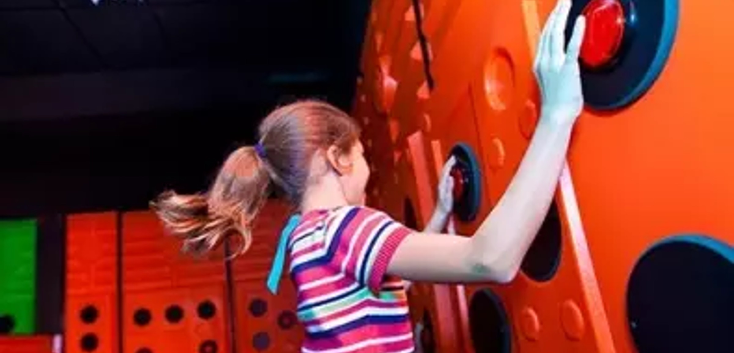 A girl presses buttons playing Oliver's Time Challenge at Great Wolf Lodge indoor water park and resort.