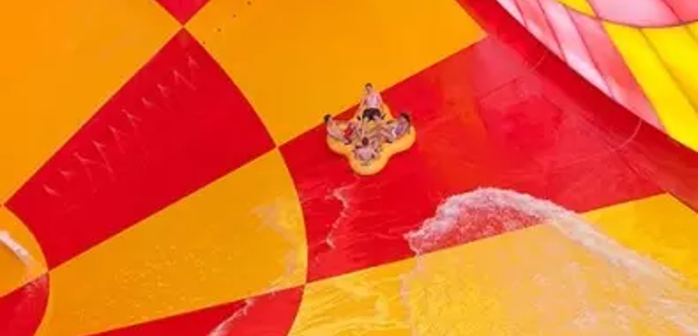 A family of four in a tube rides down the Howlin' Tornado water slide at Great Wolf Lodge indoor water park and resort.