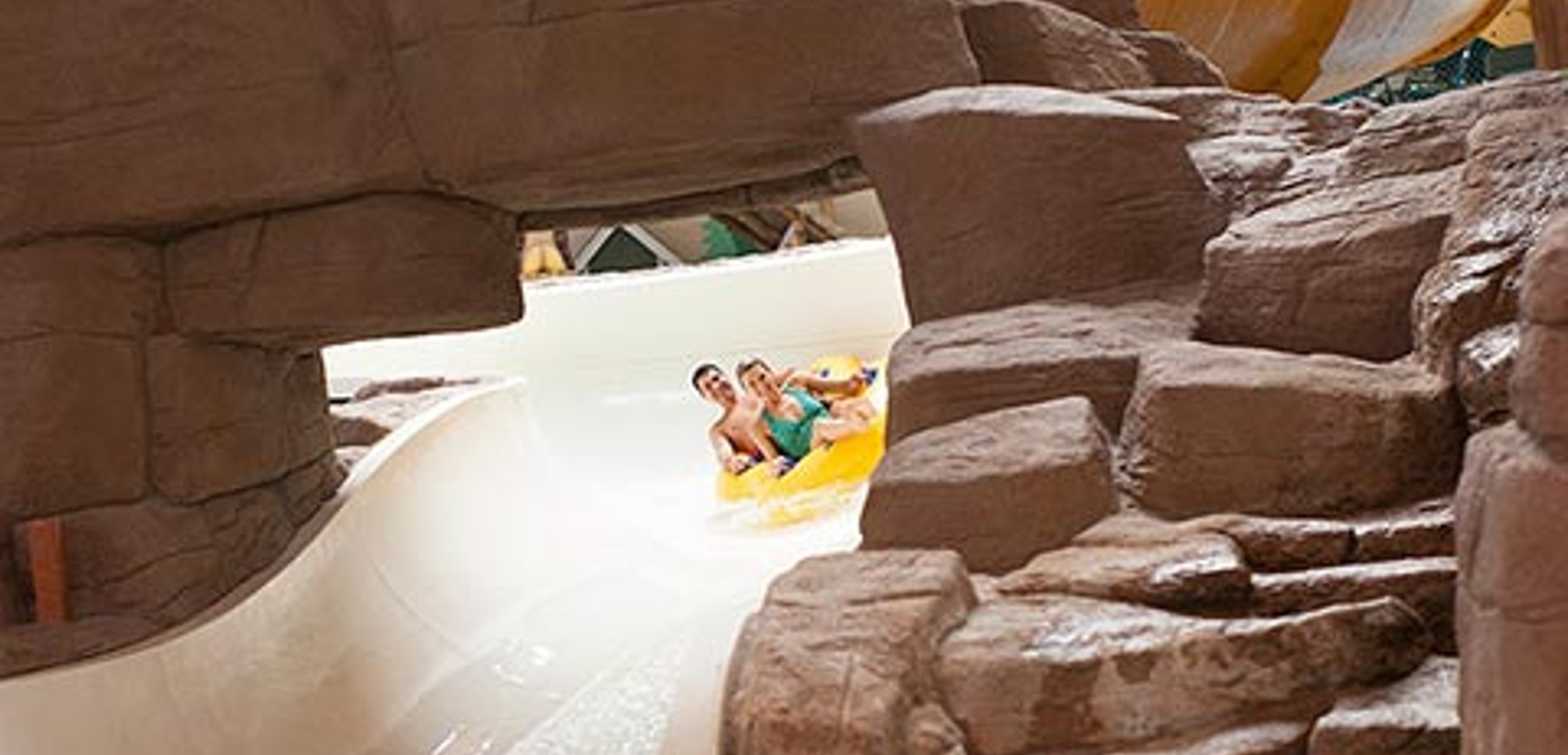 A couple race down the Lookout Mountain water slide at Great Wolf Lodge indoor water park and resort.