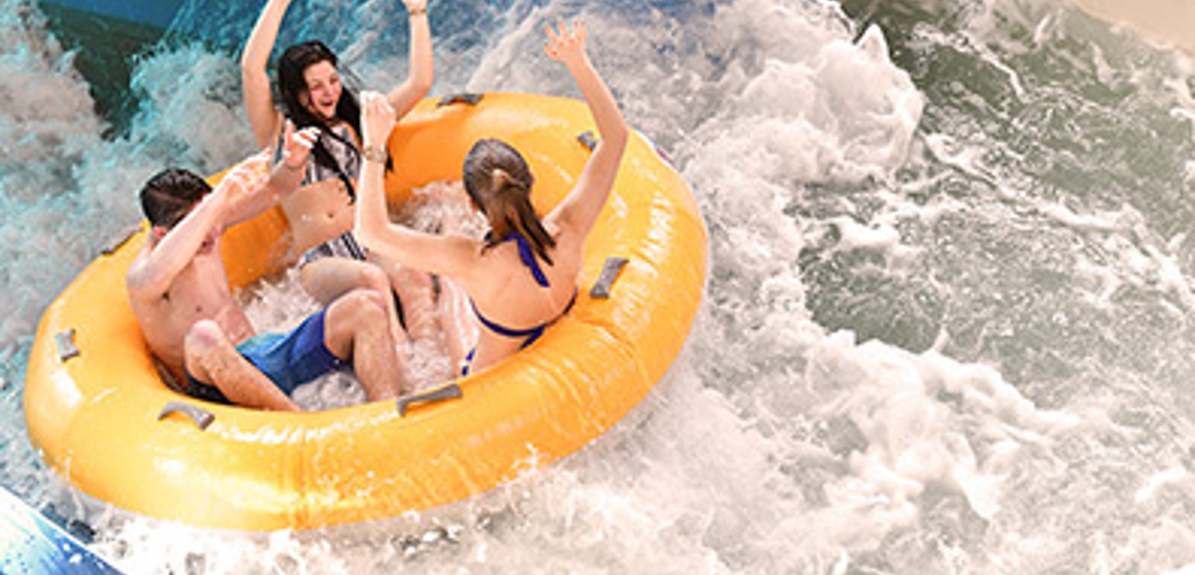 Three kids laugh as they ride in a yellow tube down a water slide