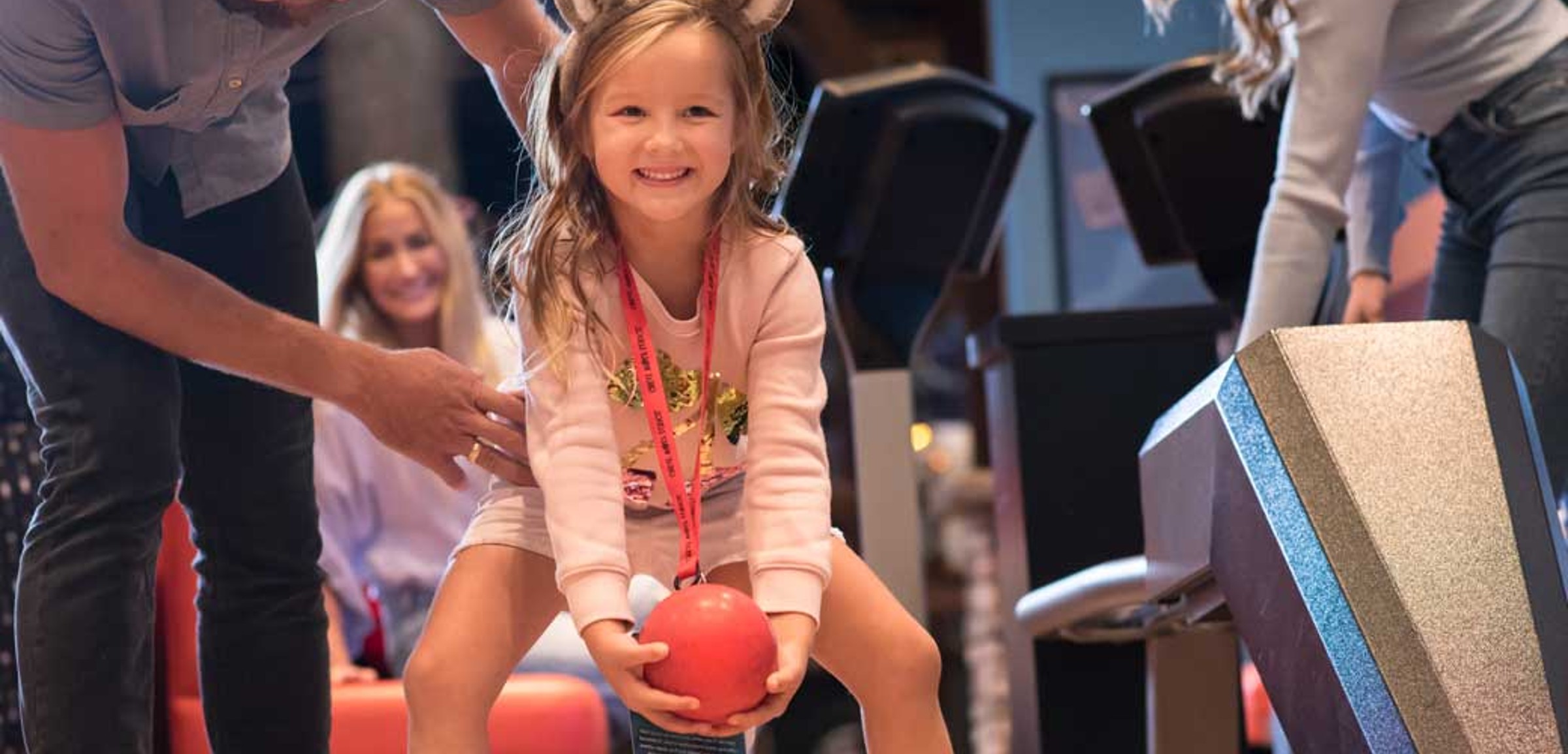 Little girl smiling while playing bowling