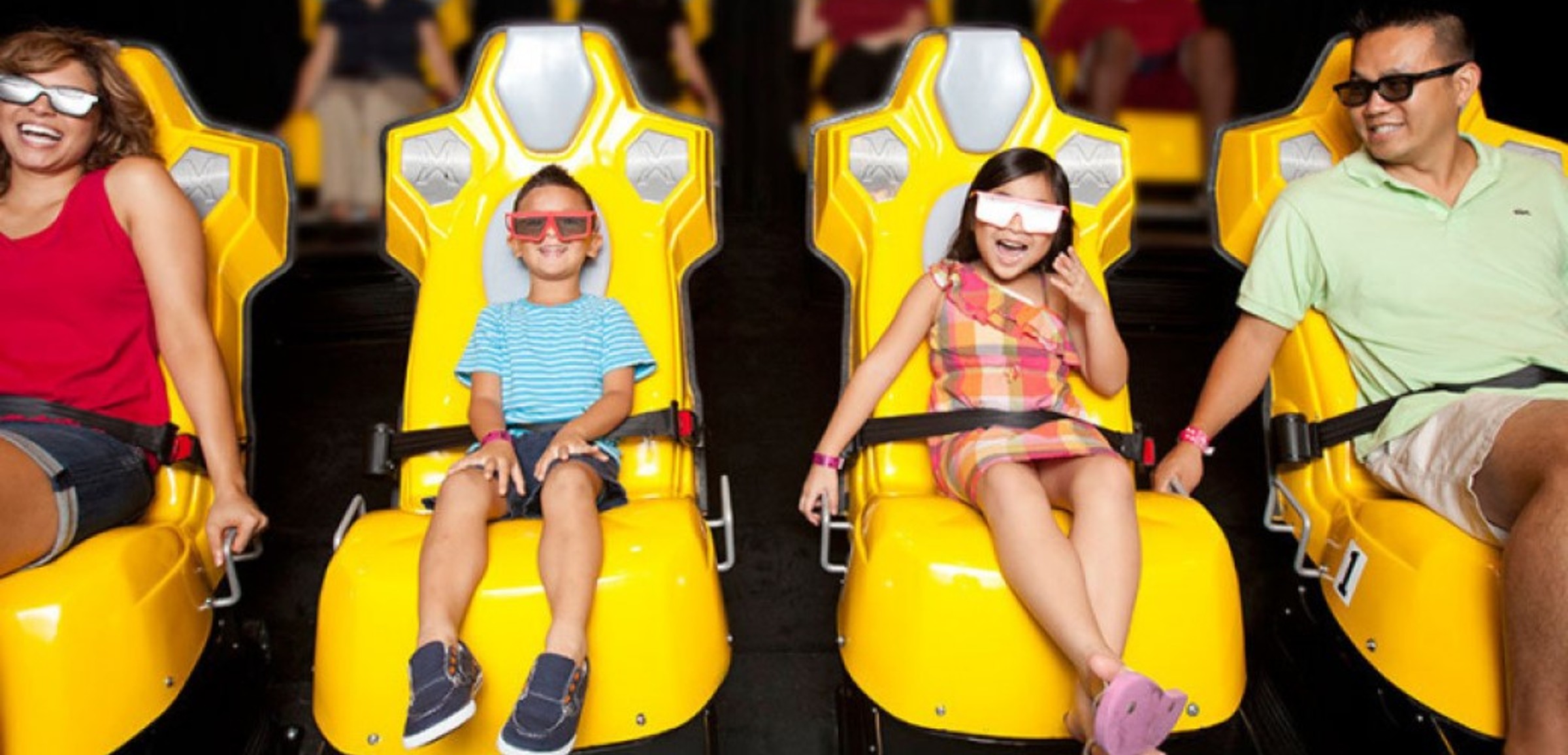 A family of four wear 3D glasses inside the Howly Wood XD Theater at Great Wolf Lodge indoor water park and resort.