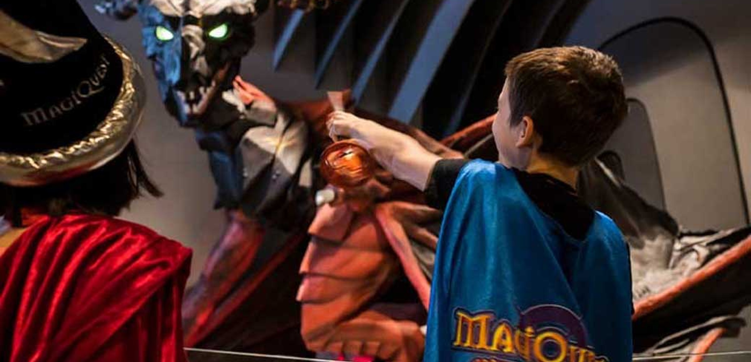 Two kids with a wand play the MagiQuest interactive game at Great Wolf Lodge indoor water park and resort.