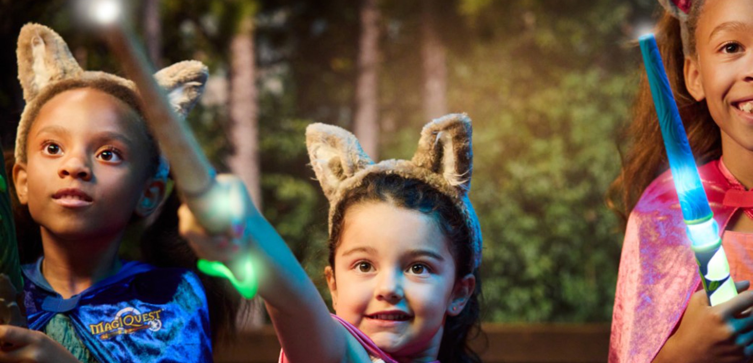 little girl placing a cape on little girl at MagiQuest at Great Wolf Lodge indoor water park and resort.