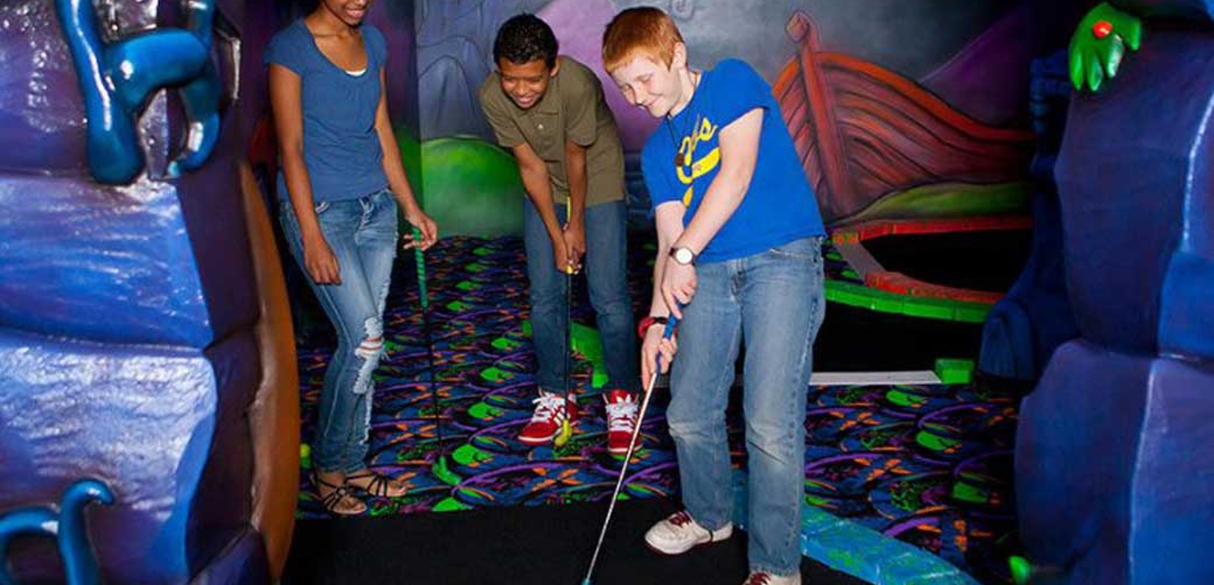 teenagers play a round of mini golg