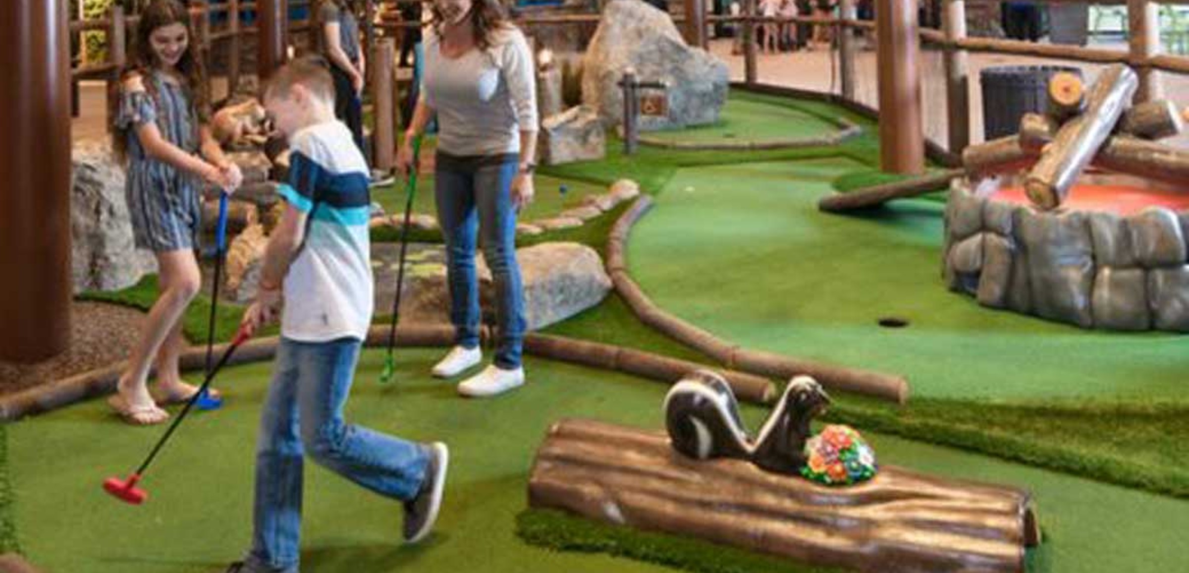 A family plays a round of mini golf at Great Wolf Lodge indoor water park and resort.