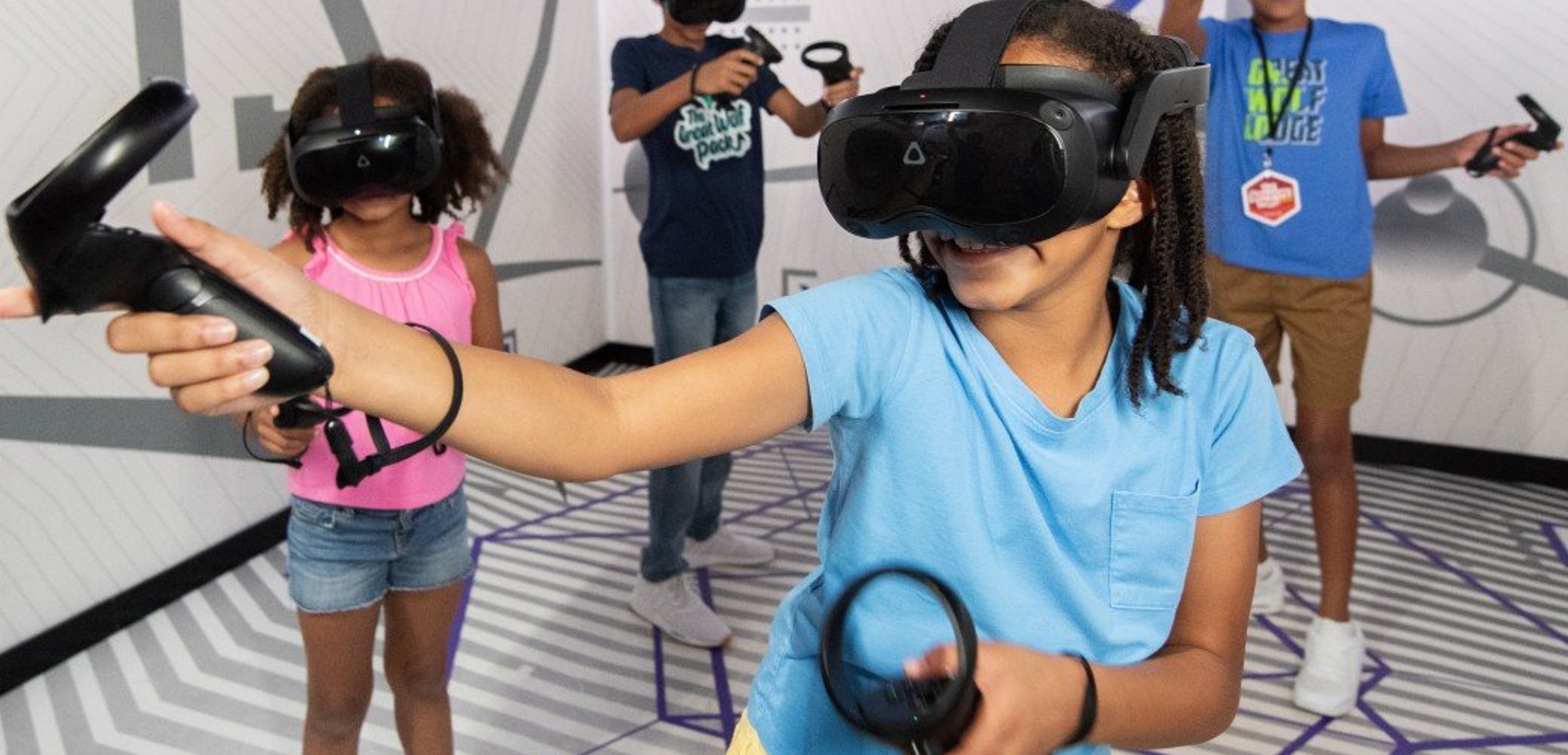 Kids wearing VR headsets play with controllers indoors