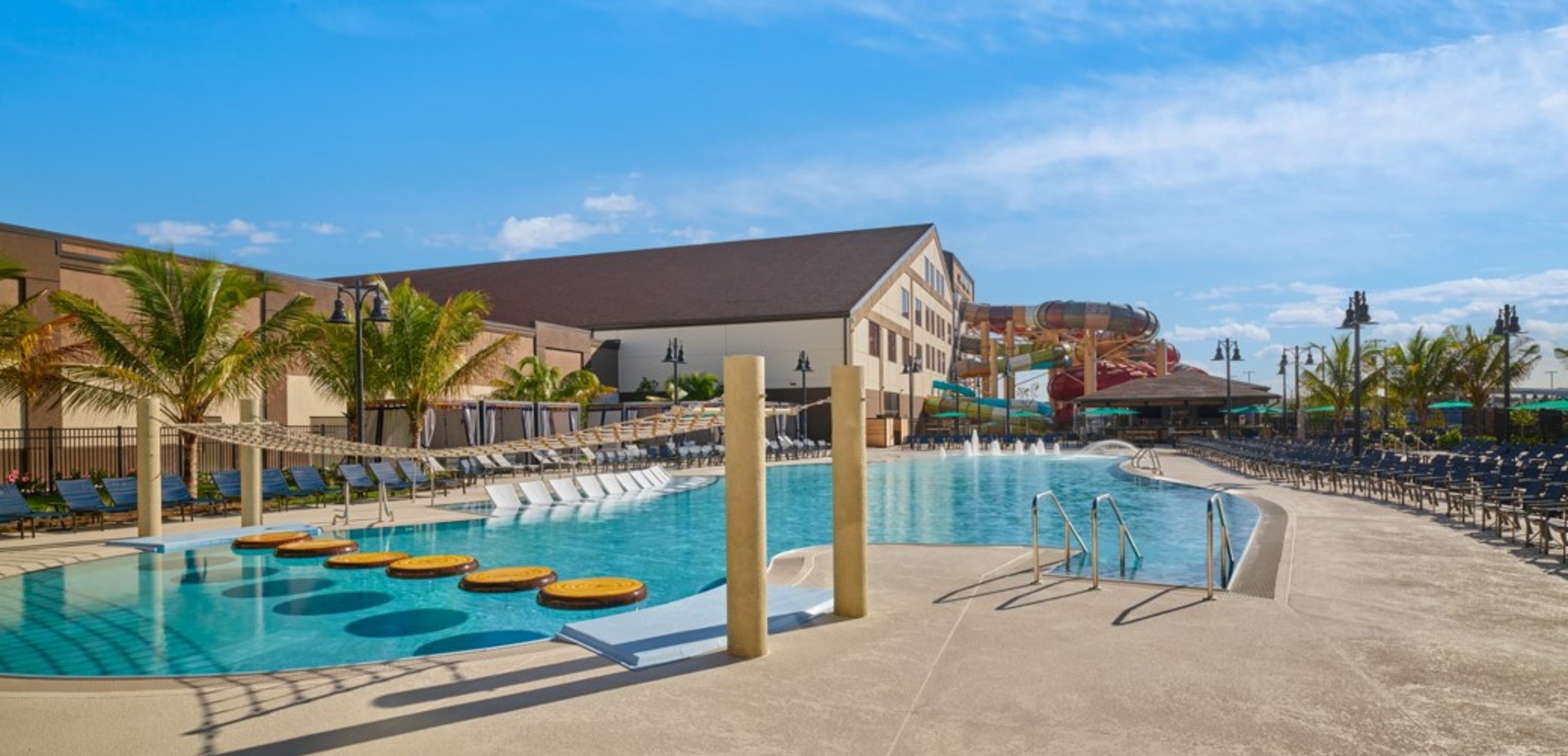 A girl balances on a lily pad float in indoor pool