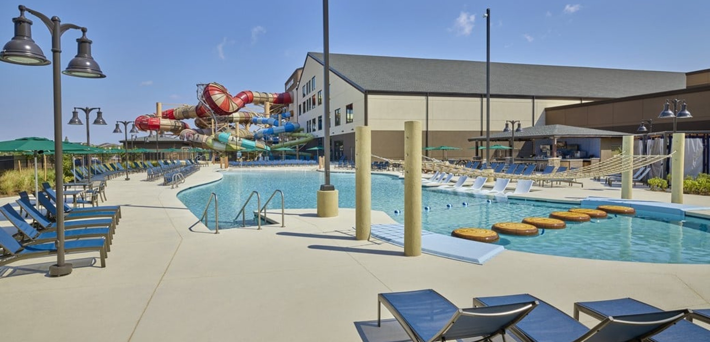 A girl balances on a lily pad float in indoor pool