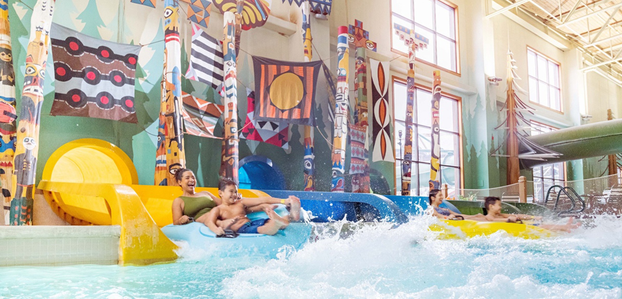 Family enjoying Bobcat Falls at Great Wolf Lodge indoor water park and resort.
