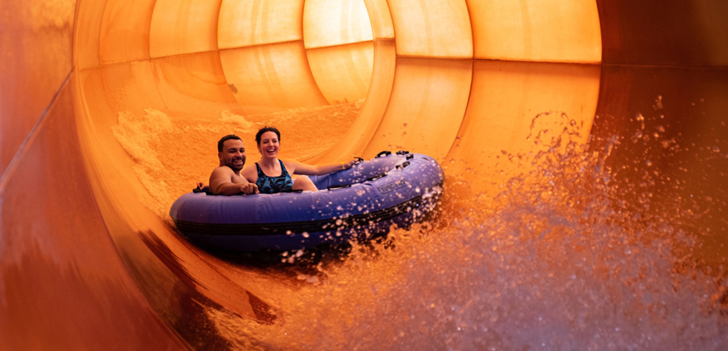 A family enjoys rafting together at Great Wolf Lodge indoor water park and resort.
