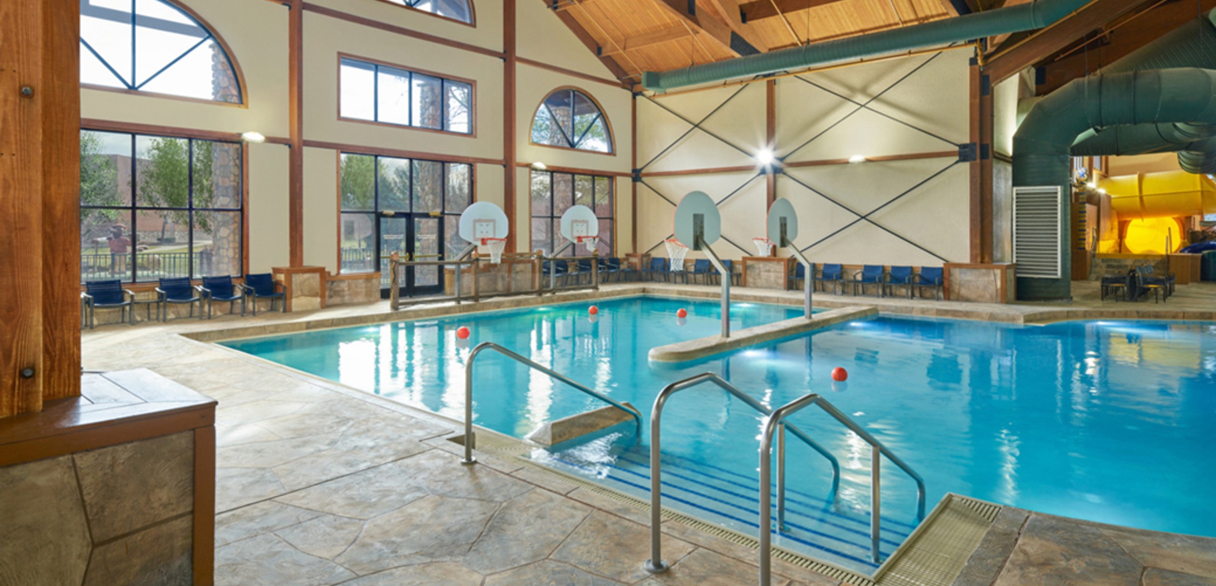 family playing basketball in indoor pool 