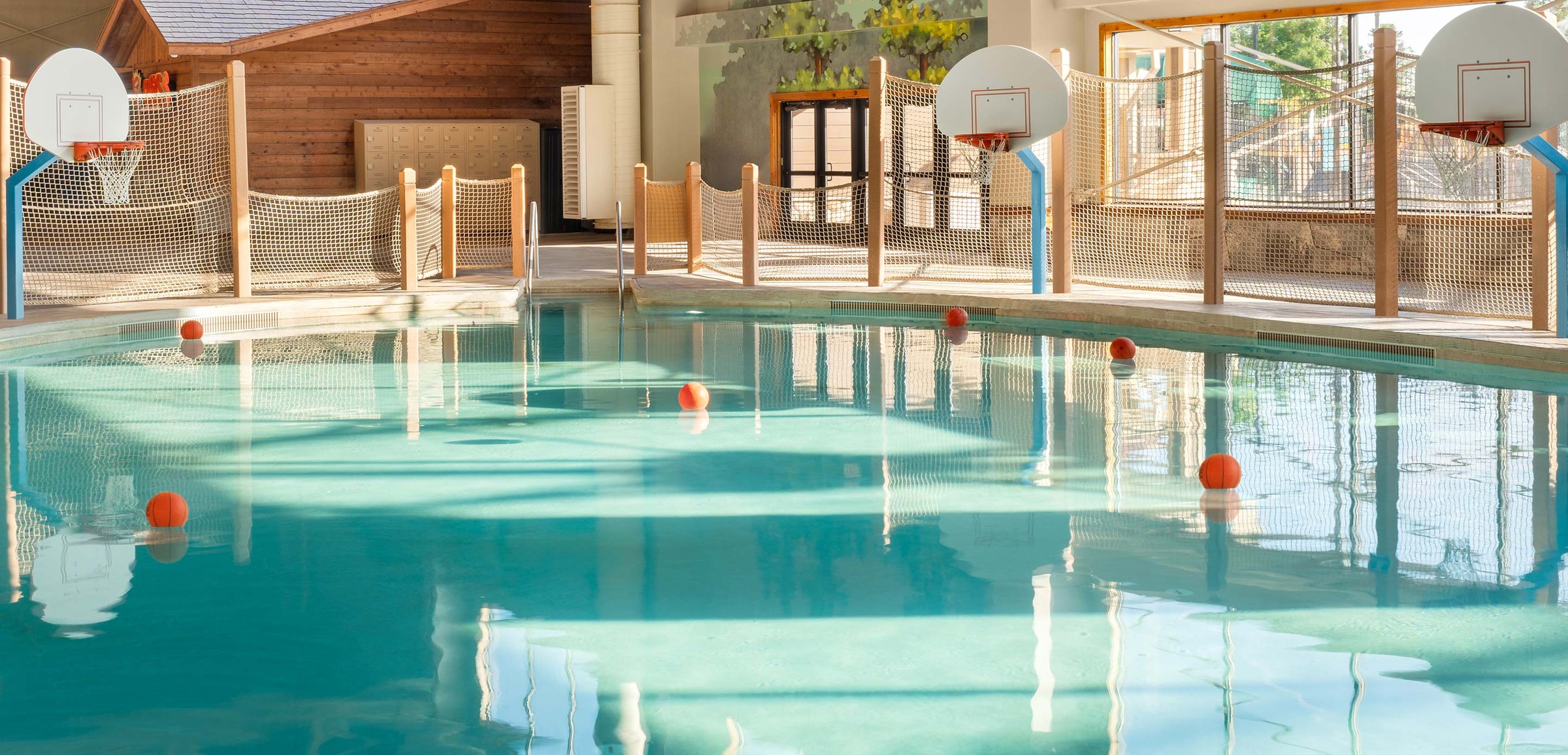 family playing basketball in indoor pool