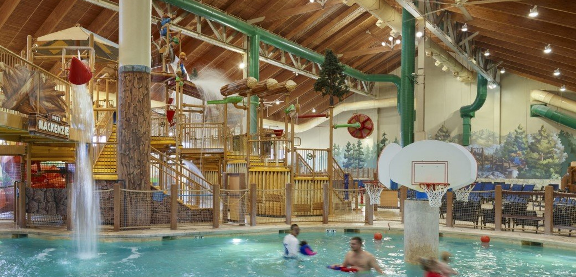 family playing basketball in indoor pool